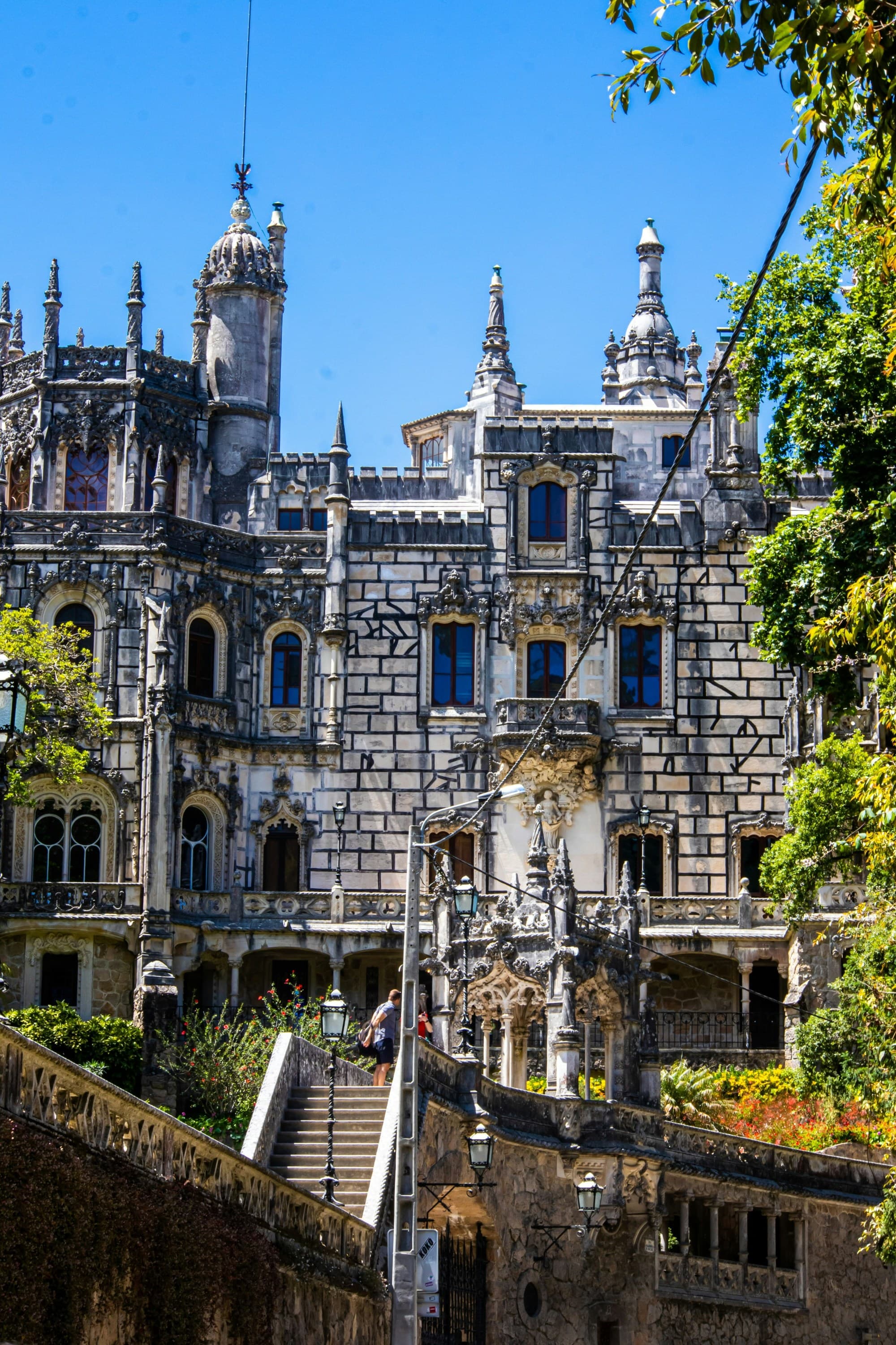A large castle with trees in front during the daytime