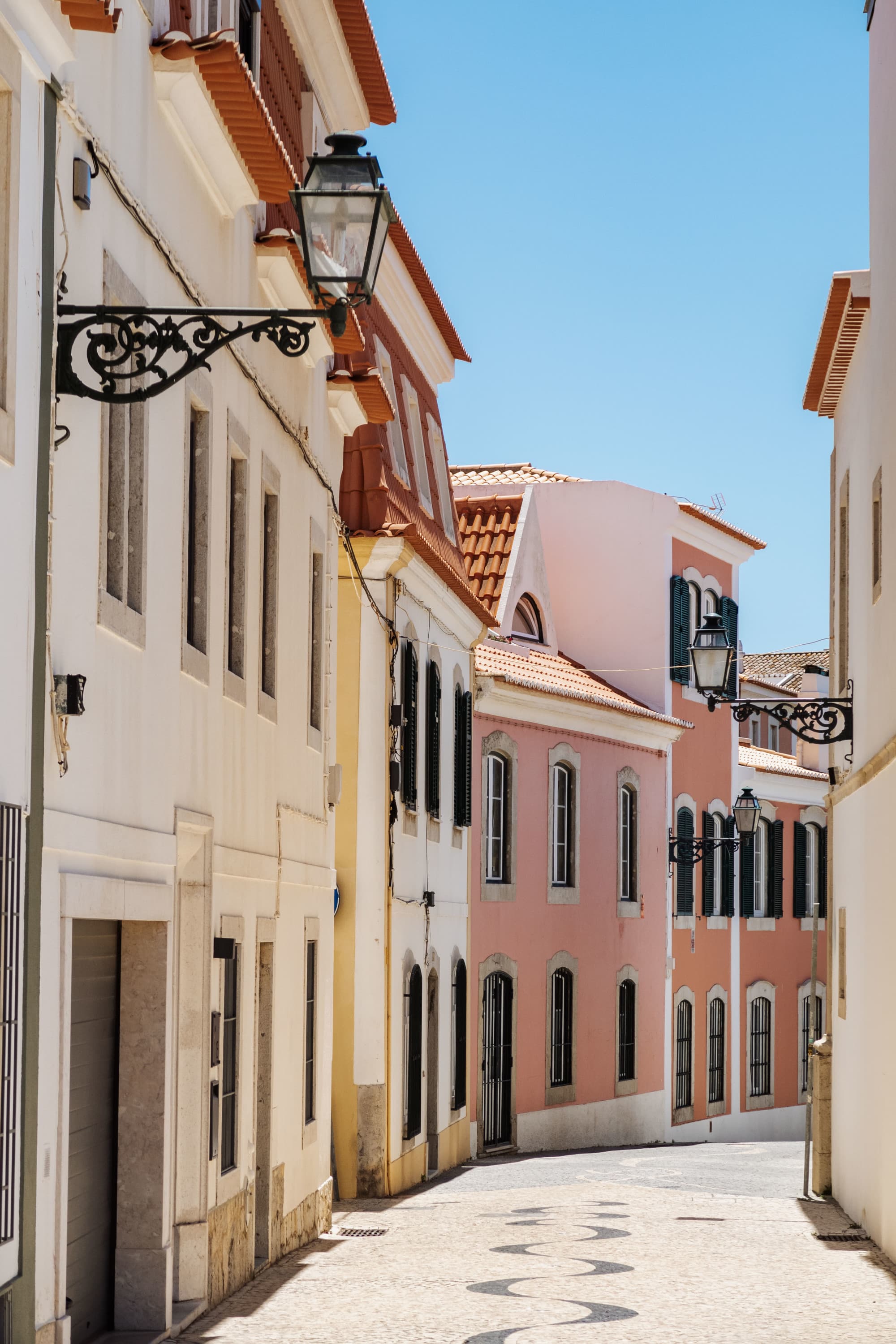 A narrow street between pastel-colored buildings