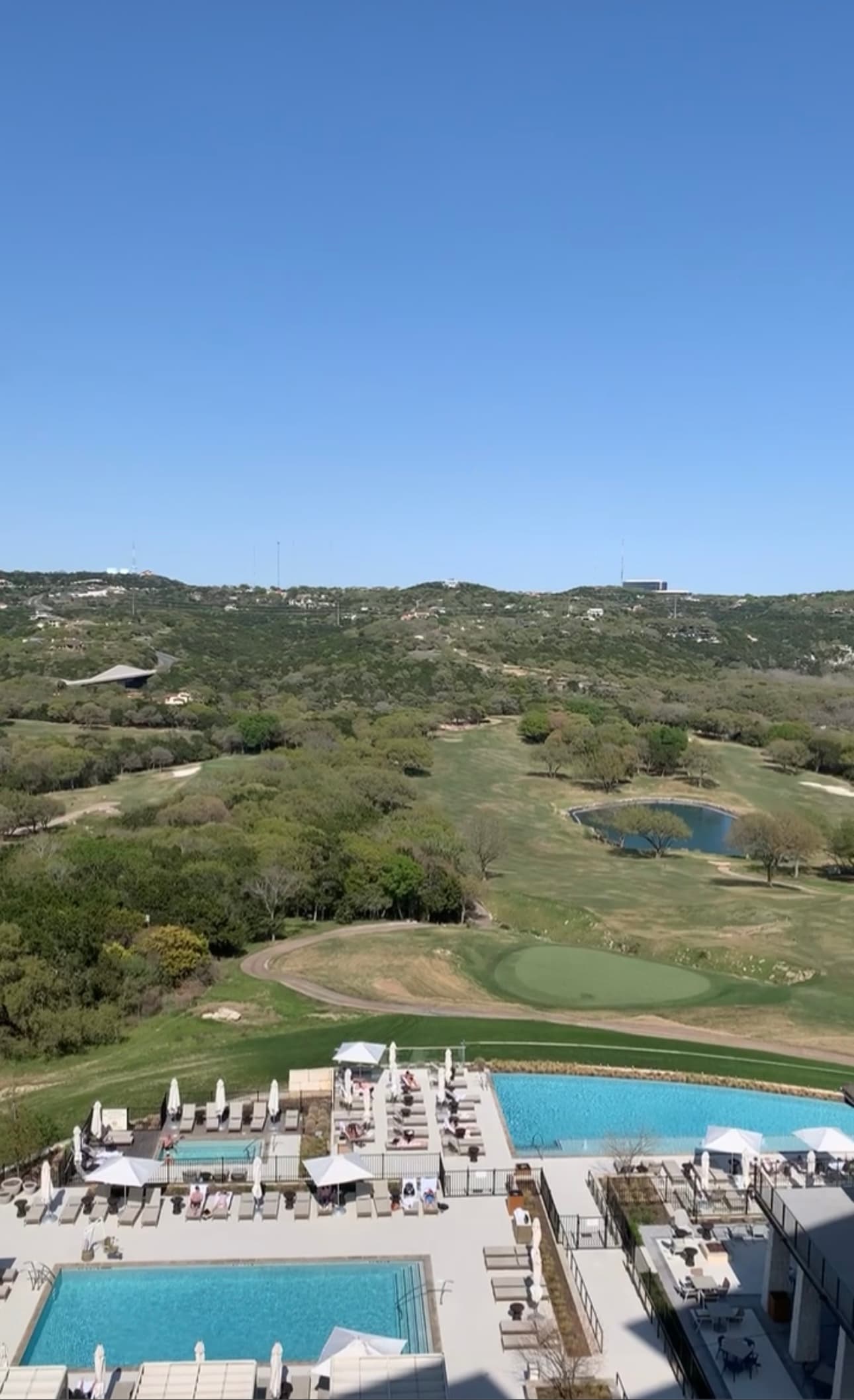 A resort pool area with a valley in the distance during the daytime