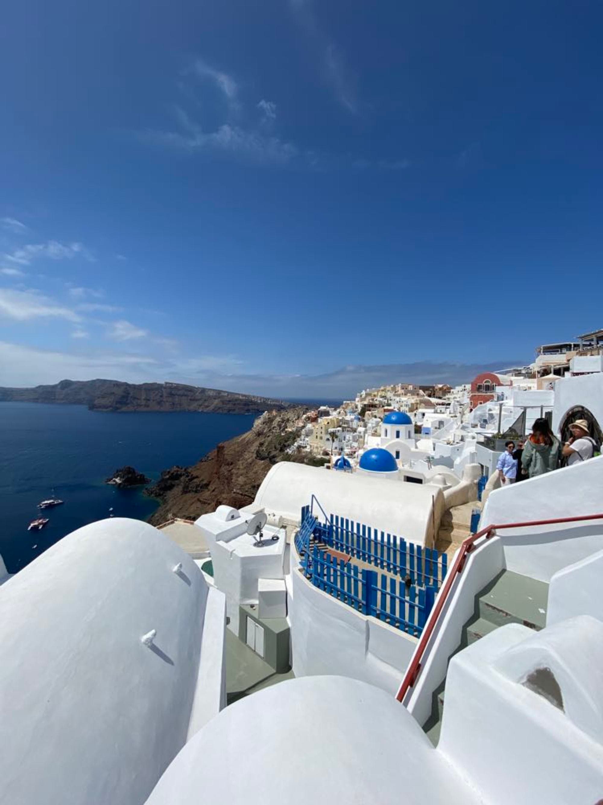 Picturesque white buildings with blue domes of Santorini, Greece, set against a stunning coastal backdrop.