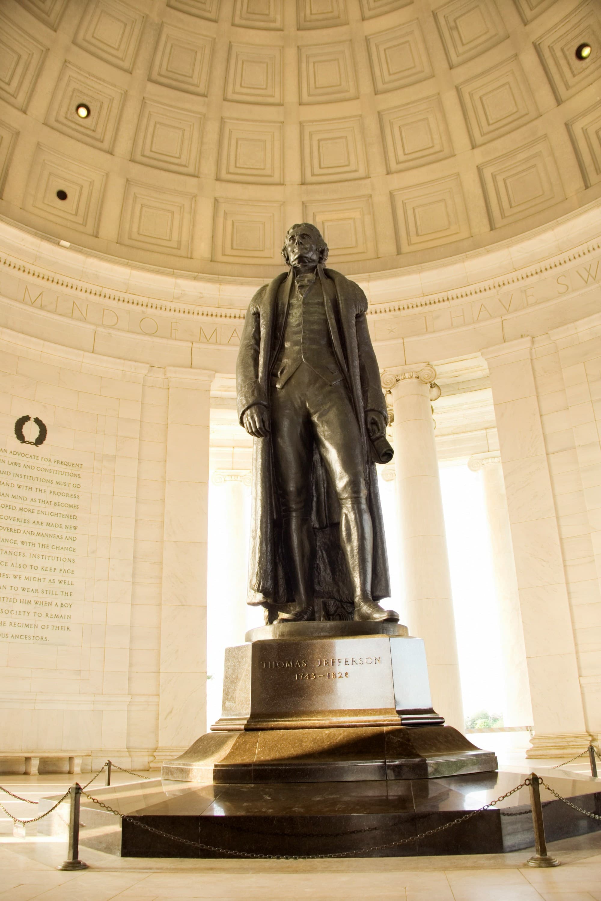 A statue of a man within a domed, marble building