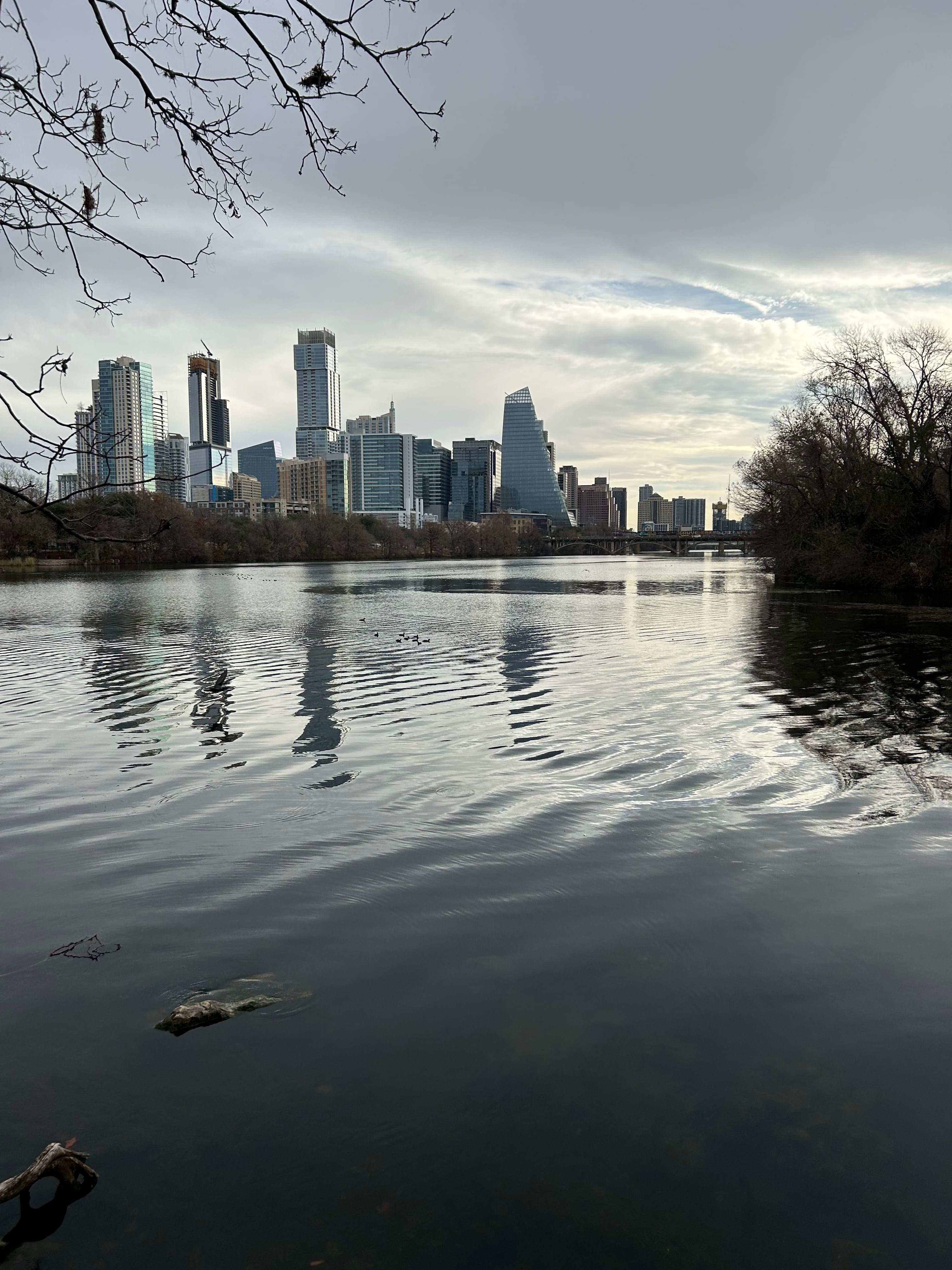 Buildings on the other side of the sea during sunset.
