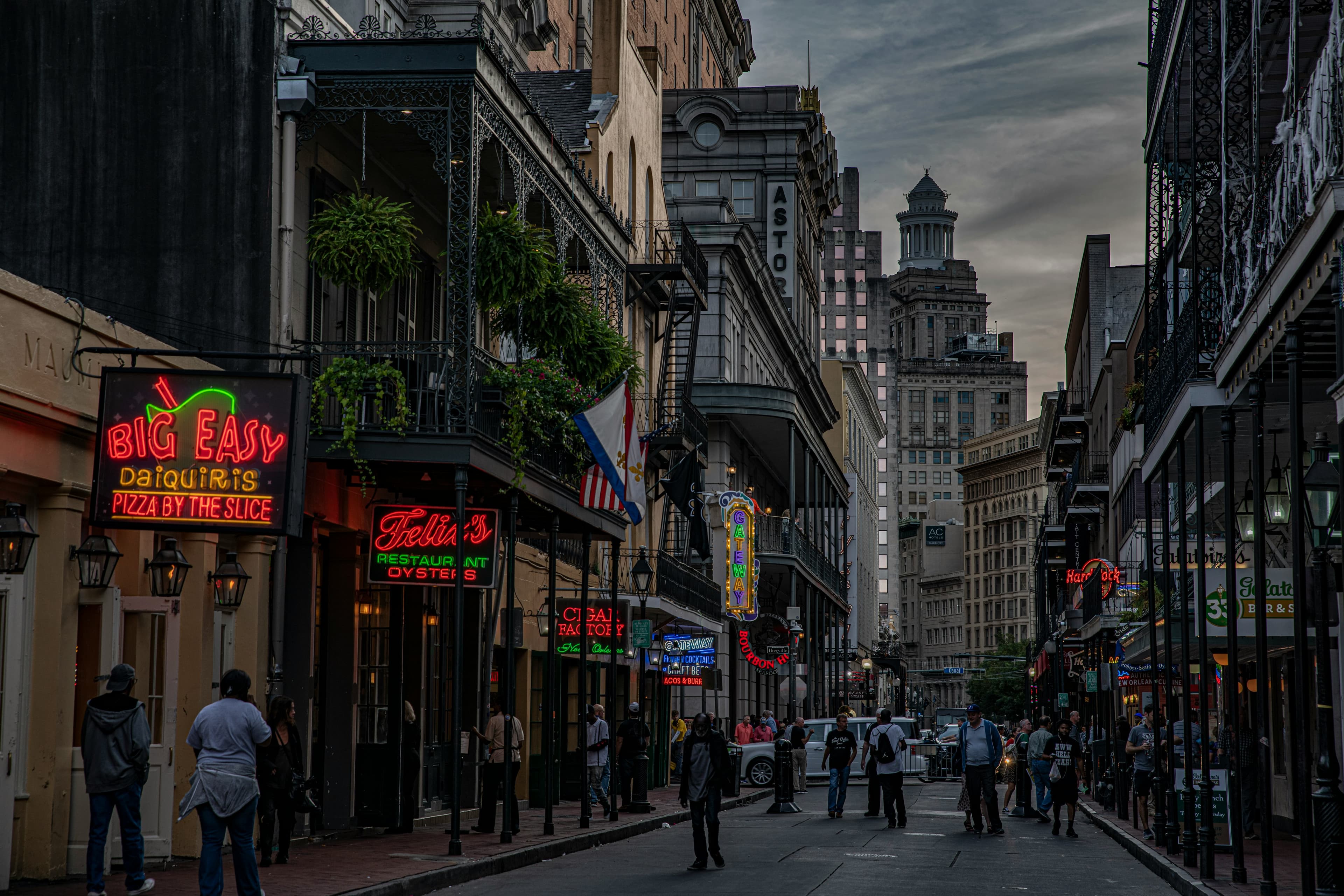 An image of downtown NOLA at dusk with 'Big Easy' establishment neon signs lit up.