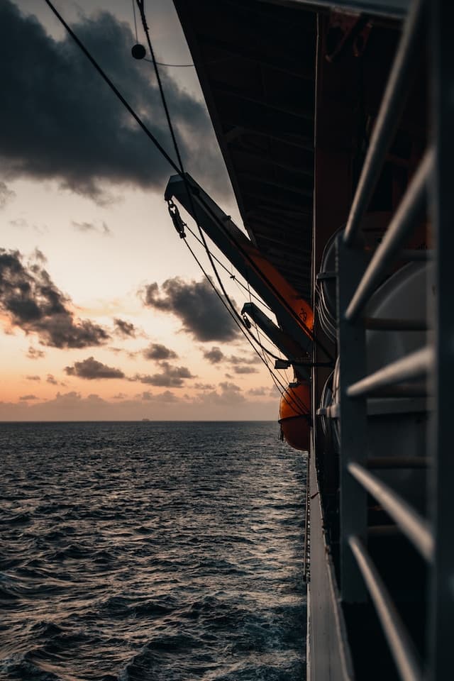 black ship on sea during sunset