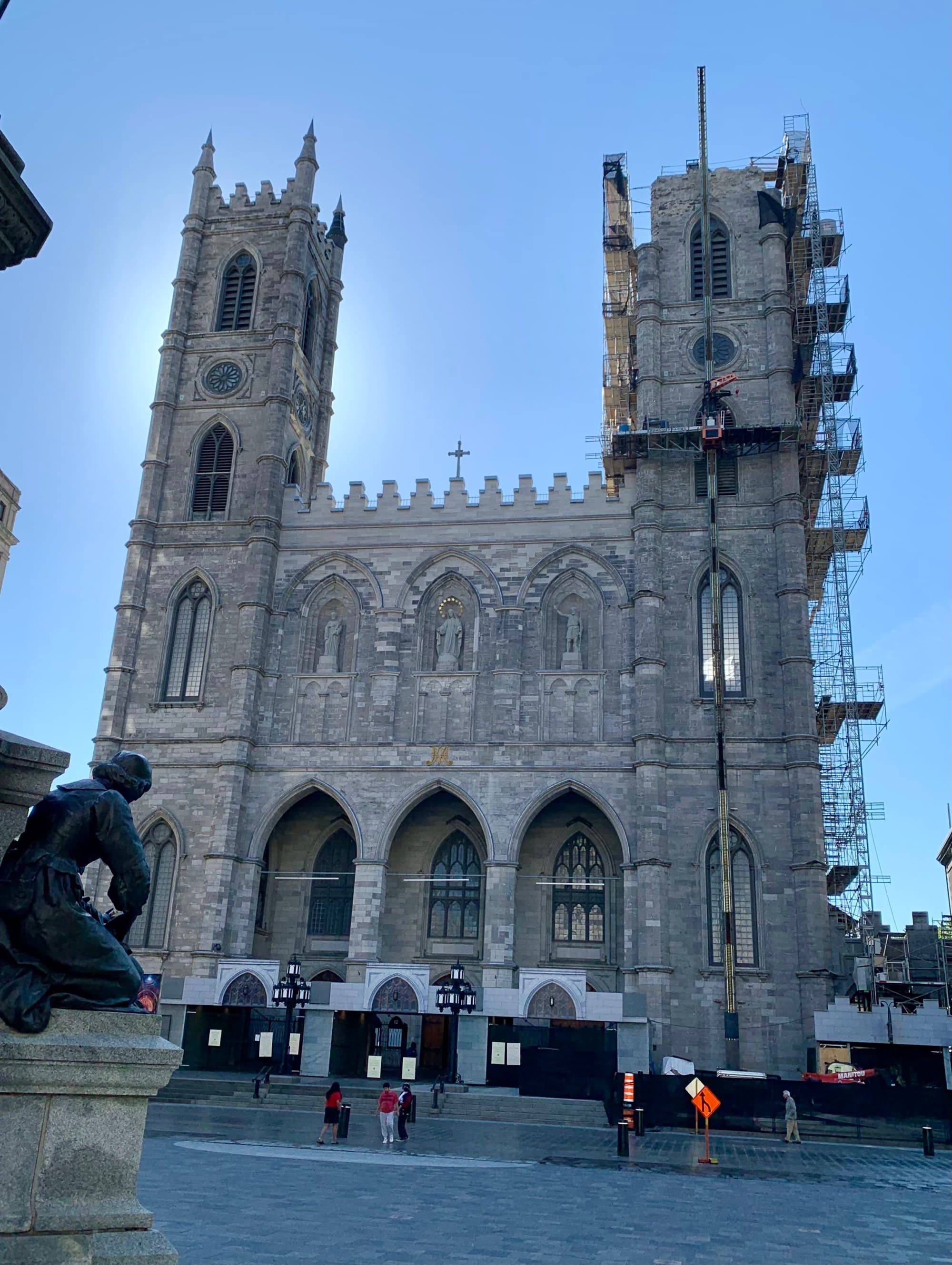The exterior of the Montreal Notre Dame in the morning with a few people outside