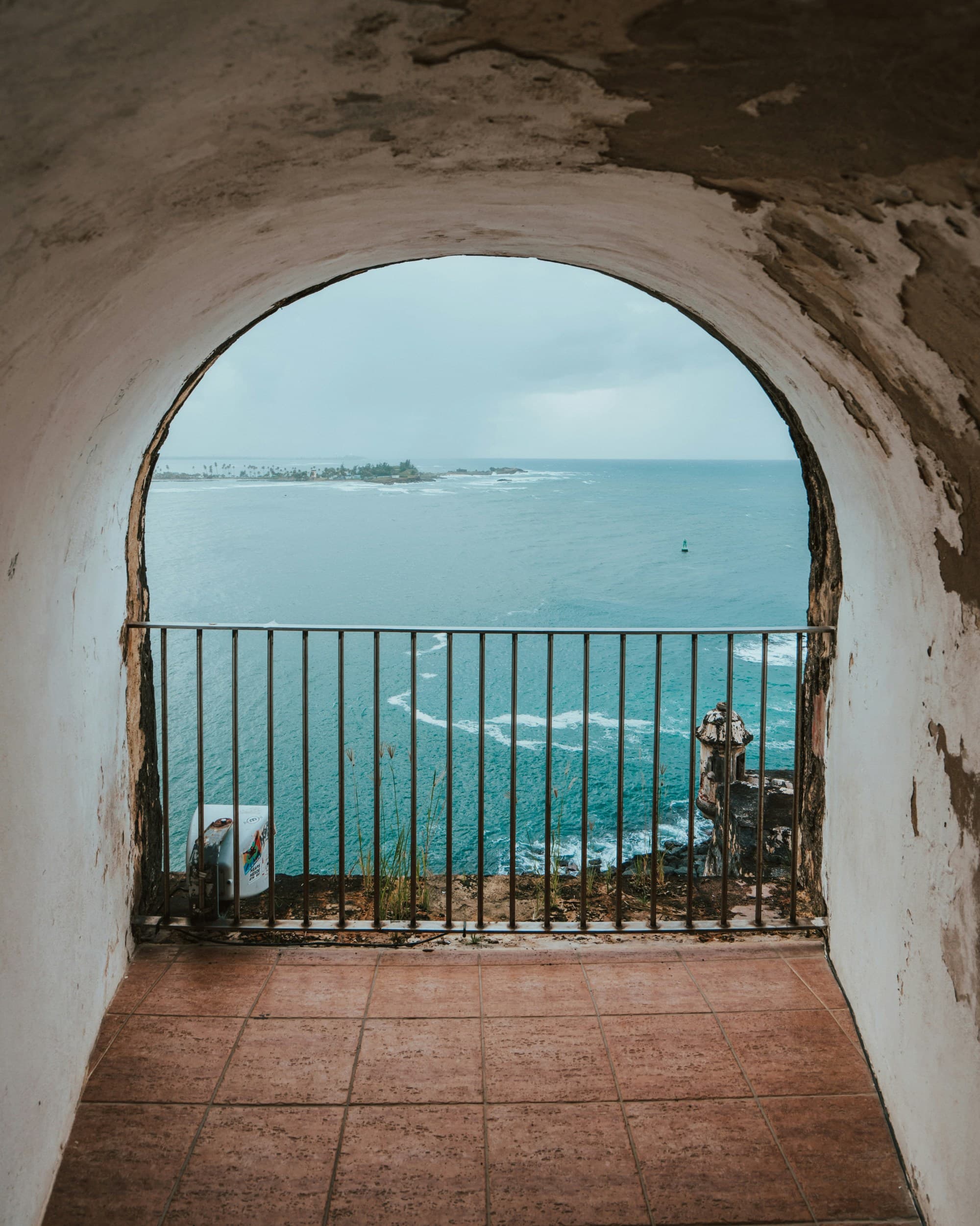 A picture of a metal fence near the blue sea during the daytime.