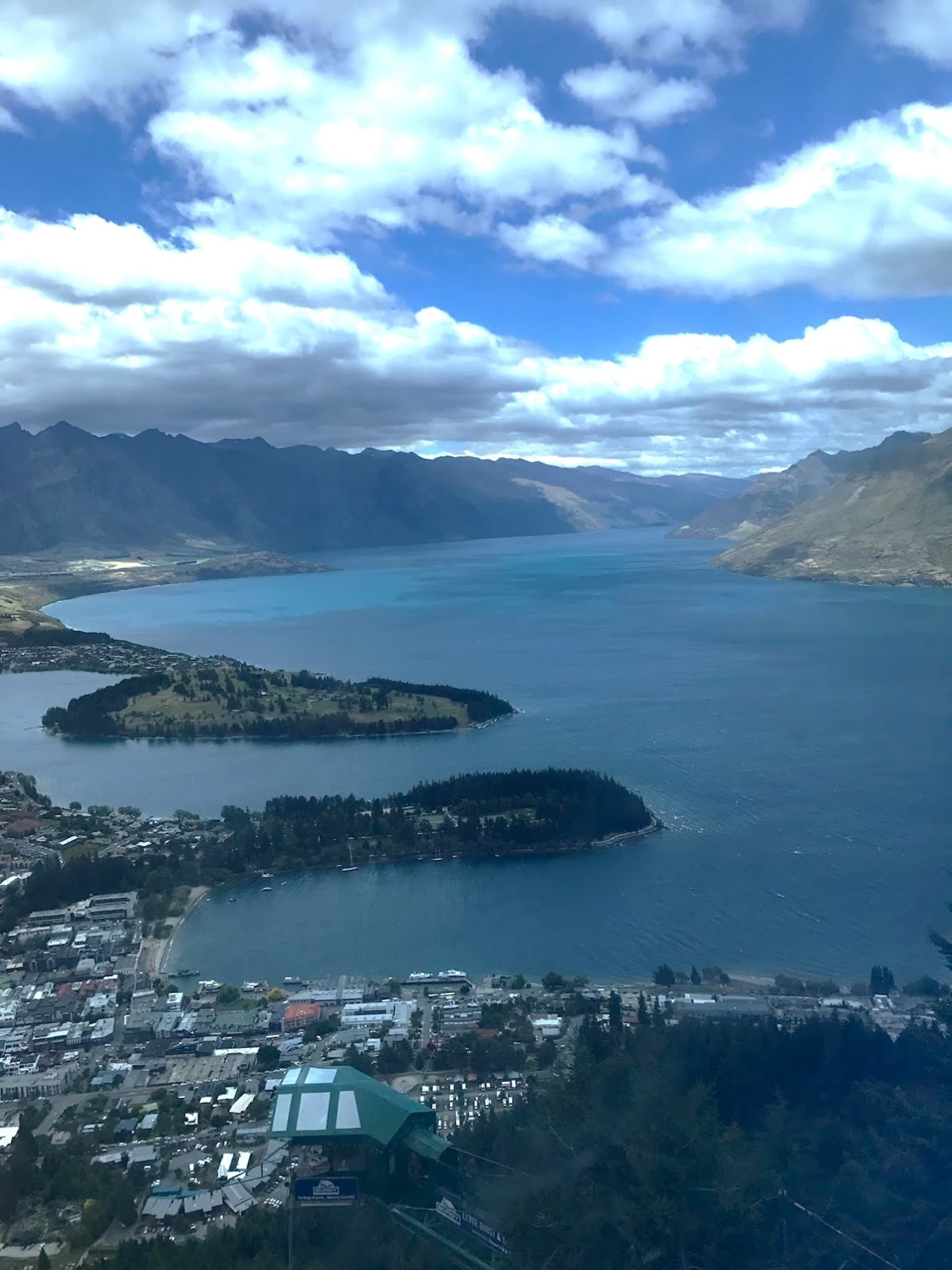 An aerial view of the city and the sea near the mountains during the daytime.
