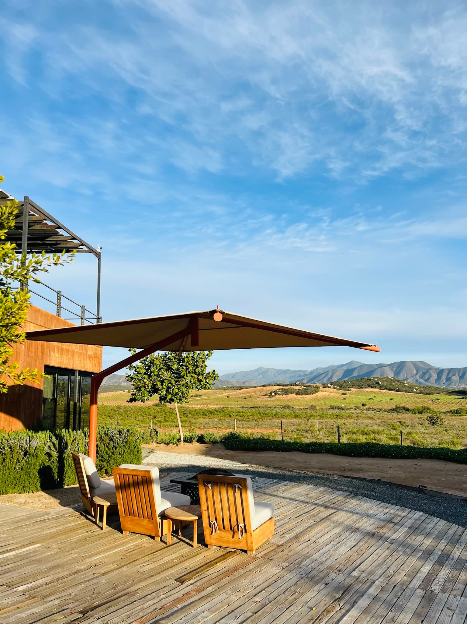 View of valley with lounge chairs on a patio.