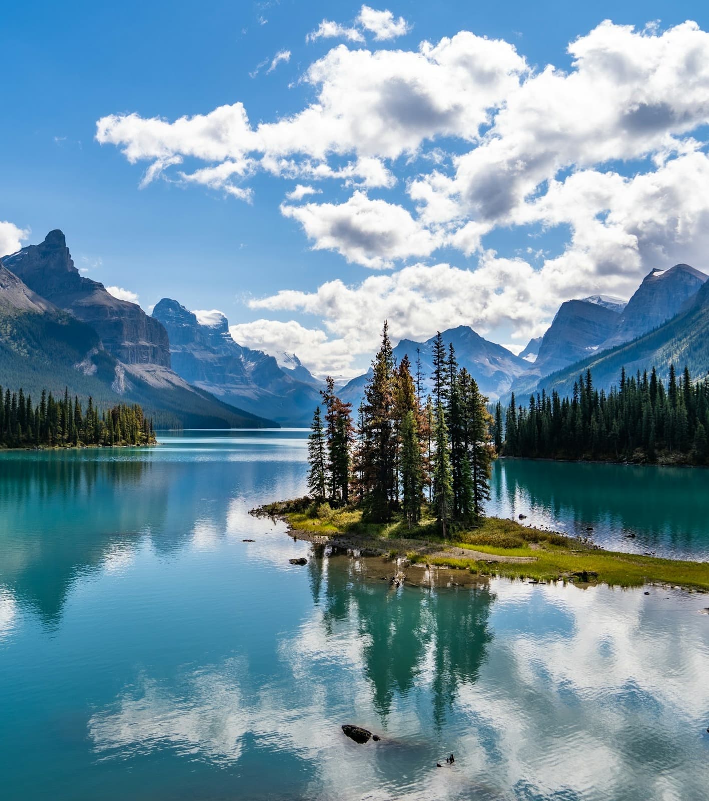 Green trees near beautiful blue lake and mountains in Spirit Island at Maligne Lake in Jasper National Park.