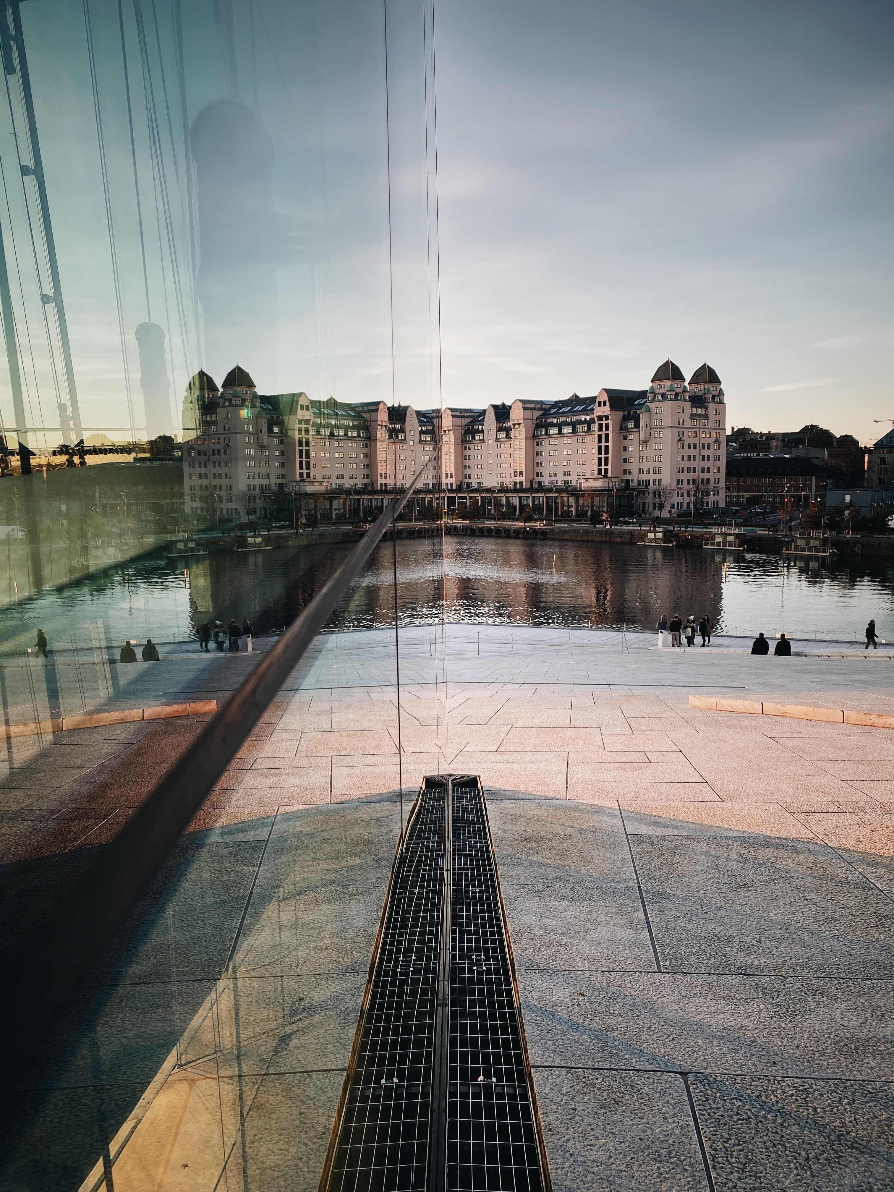 A contemporary building and a monument in front of a lake.