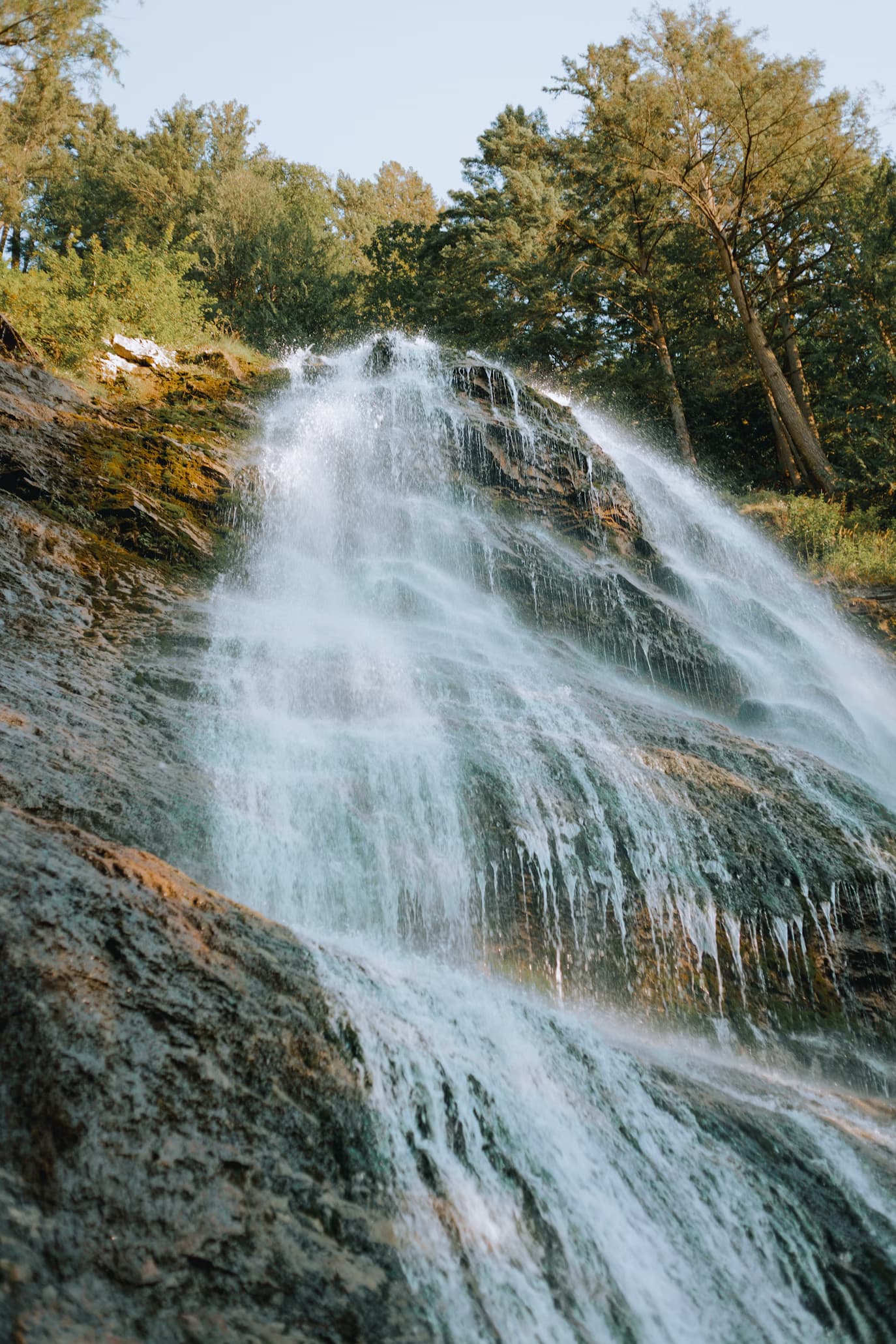 A low-angled view of a large waterfall down a cliffside