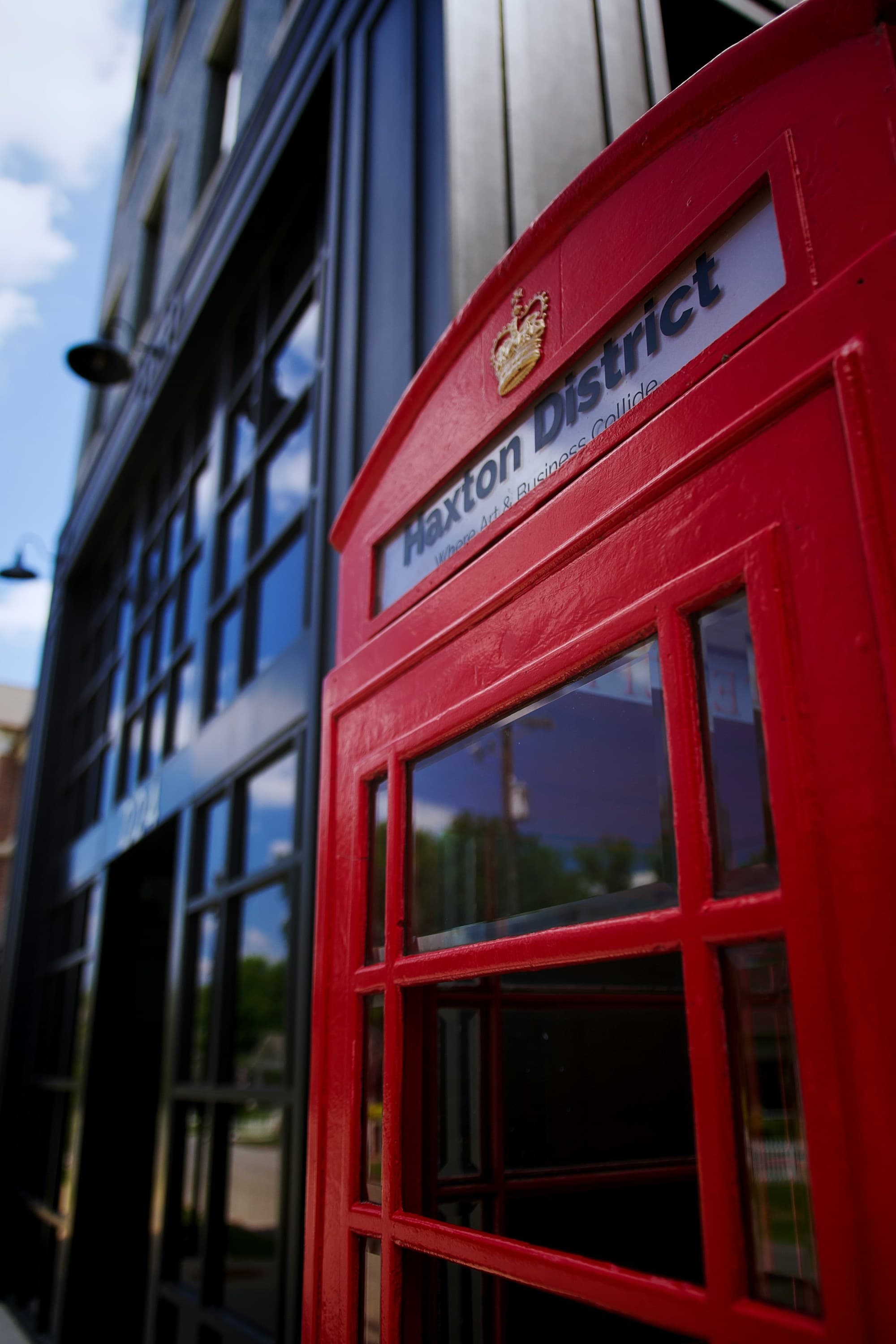 Red phone booth in front of a building.