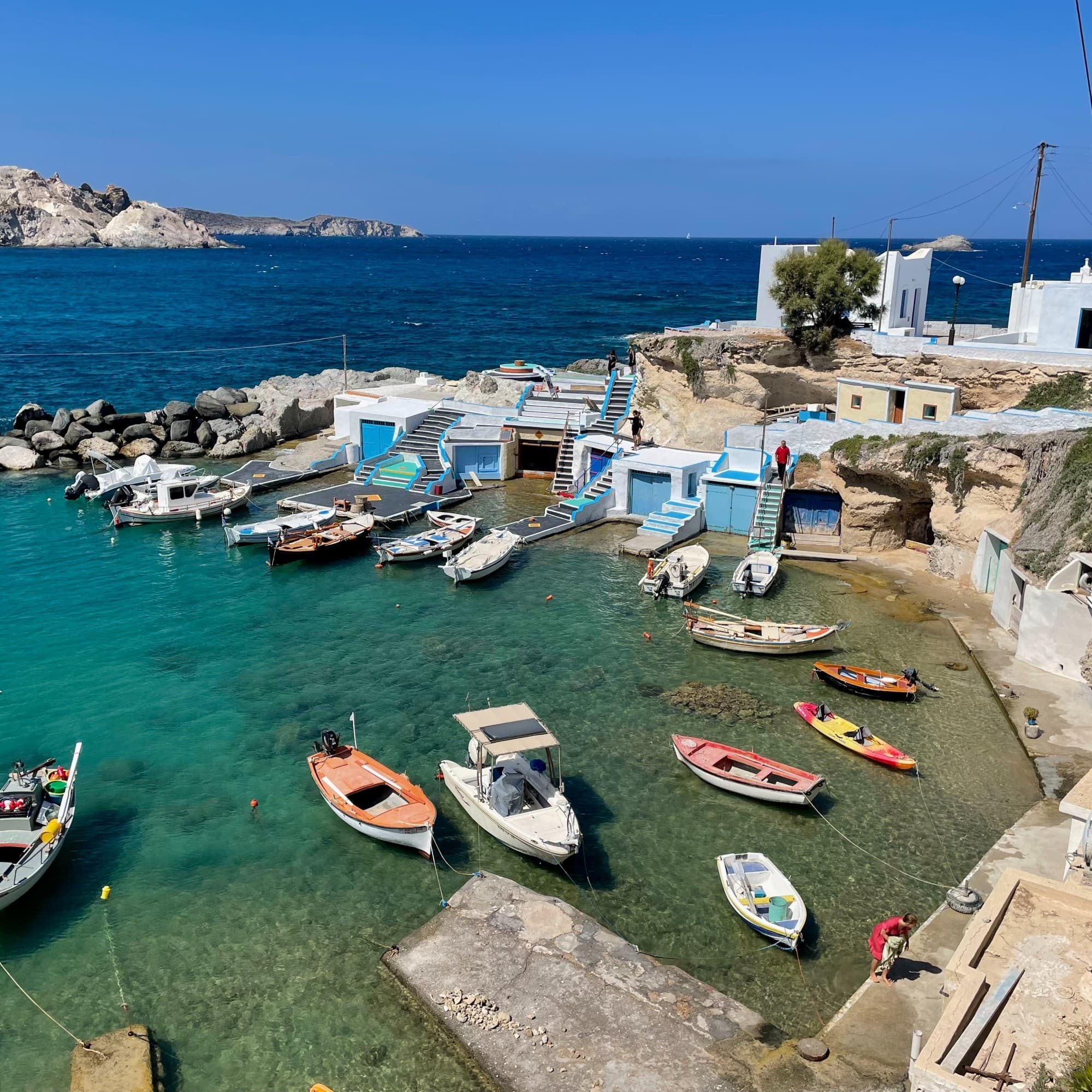 An aerial view of the shore with multiple boats anchored to the shore.