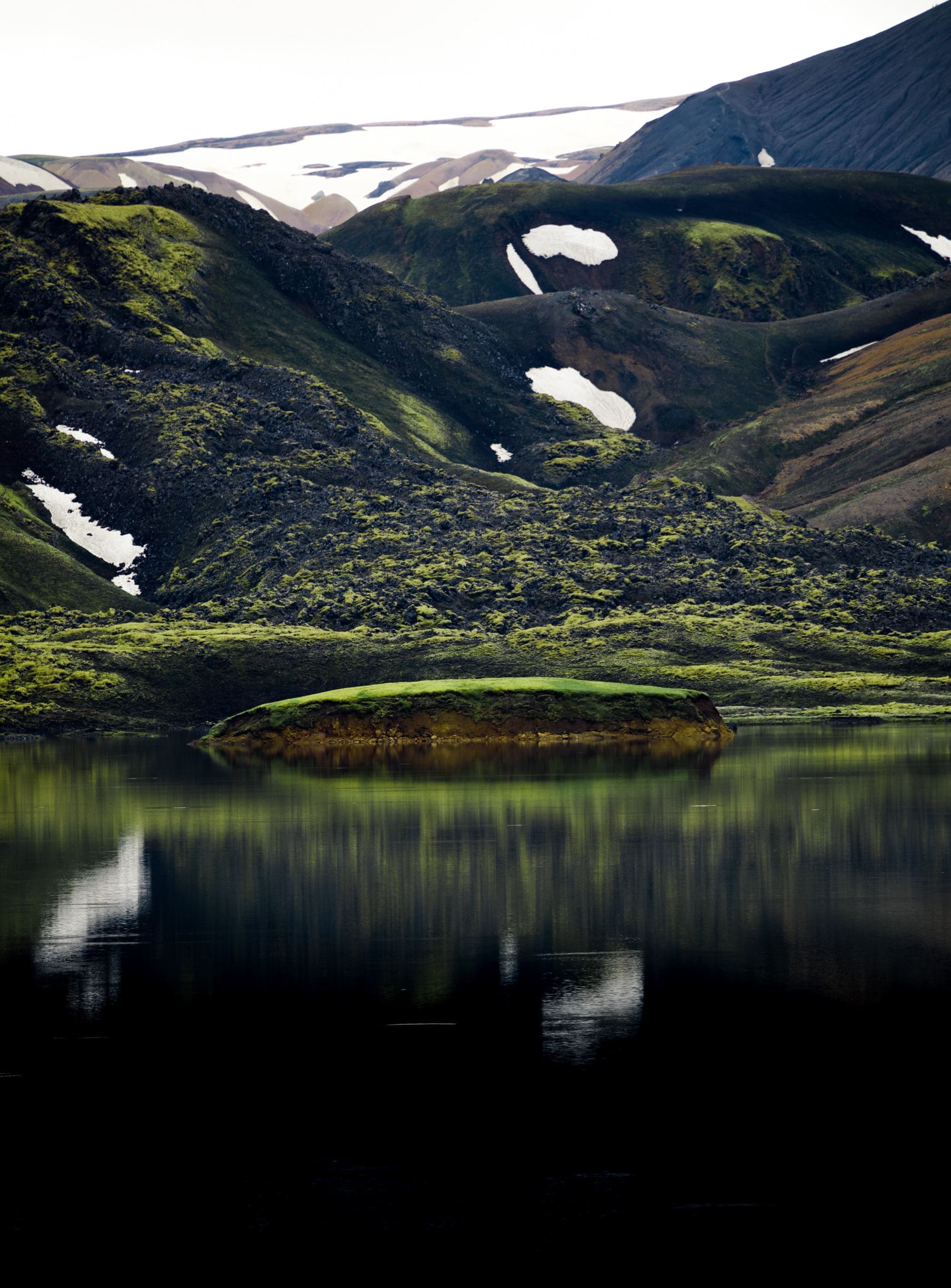 green mountain landscape with serene pond at its base