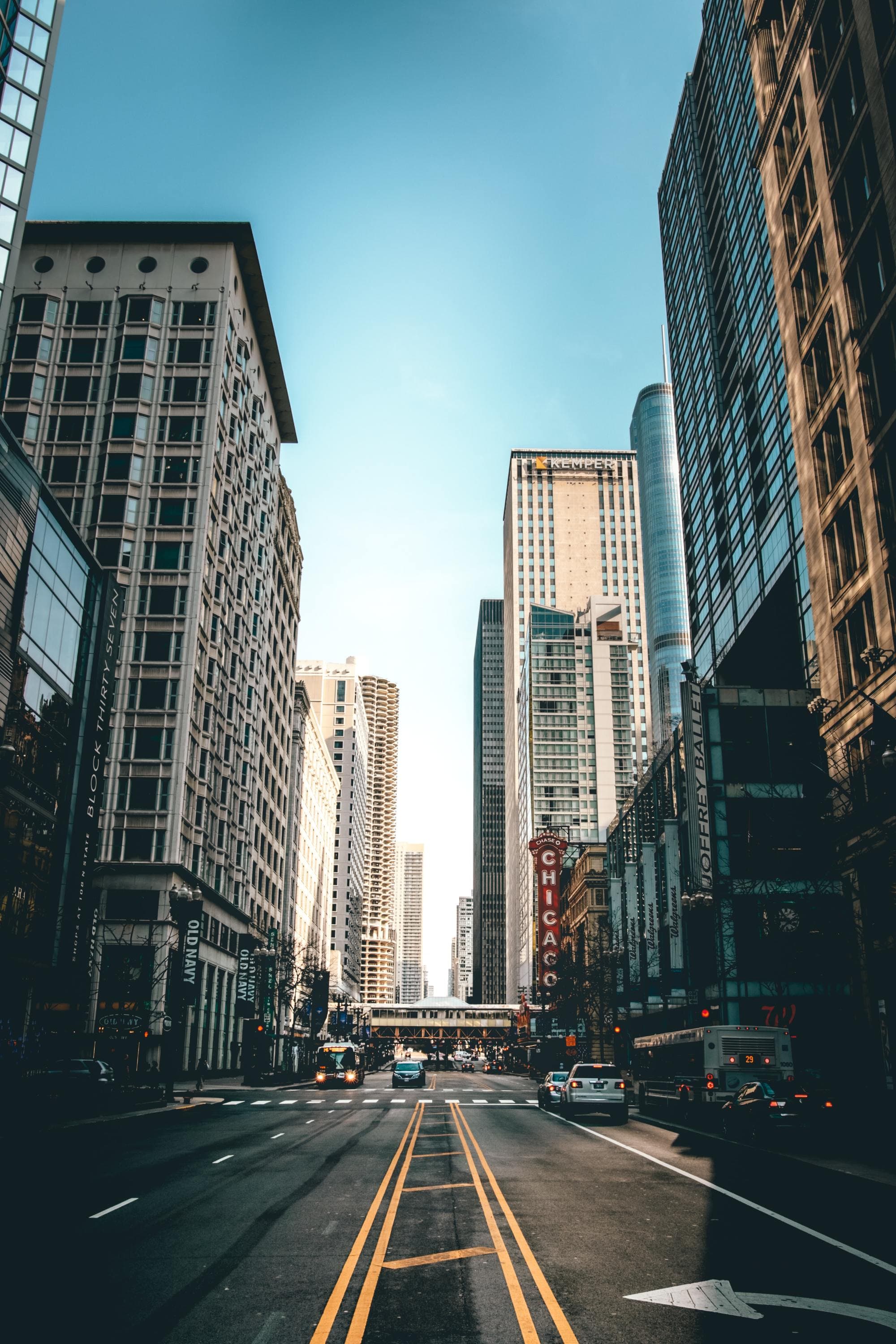 view down a city street with tall buildings on either end and blue sky