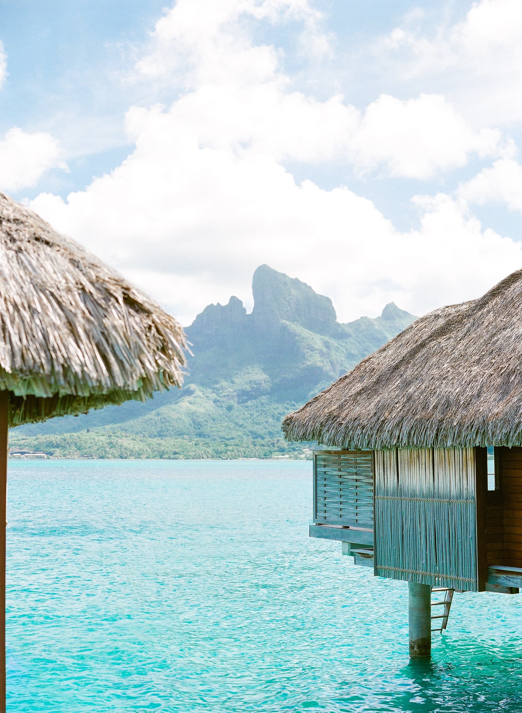 Hut on body of water with mountain in background during daytime