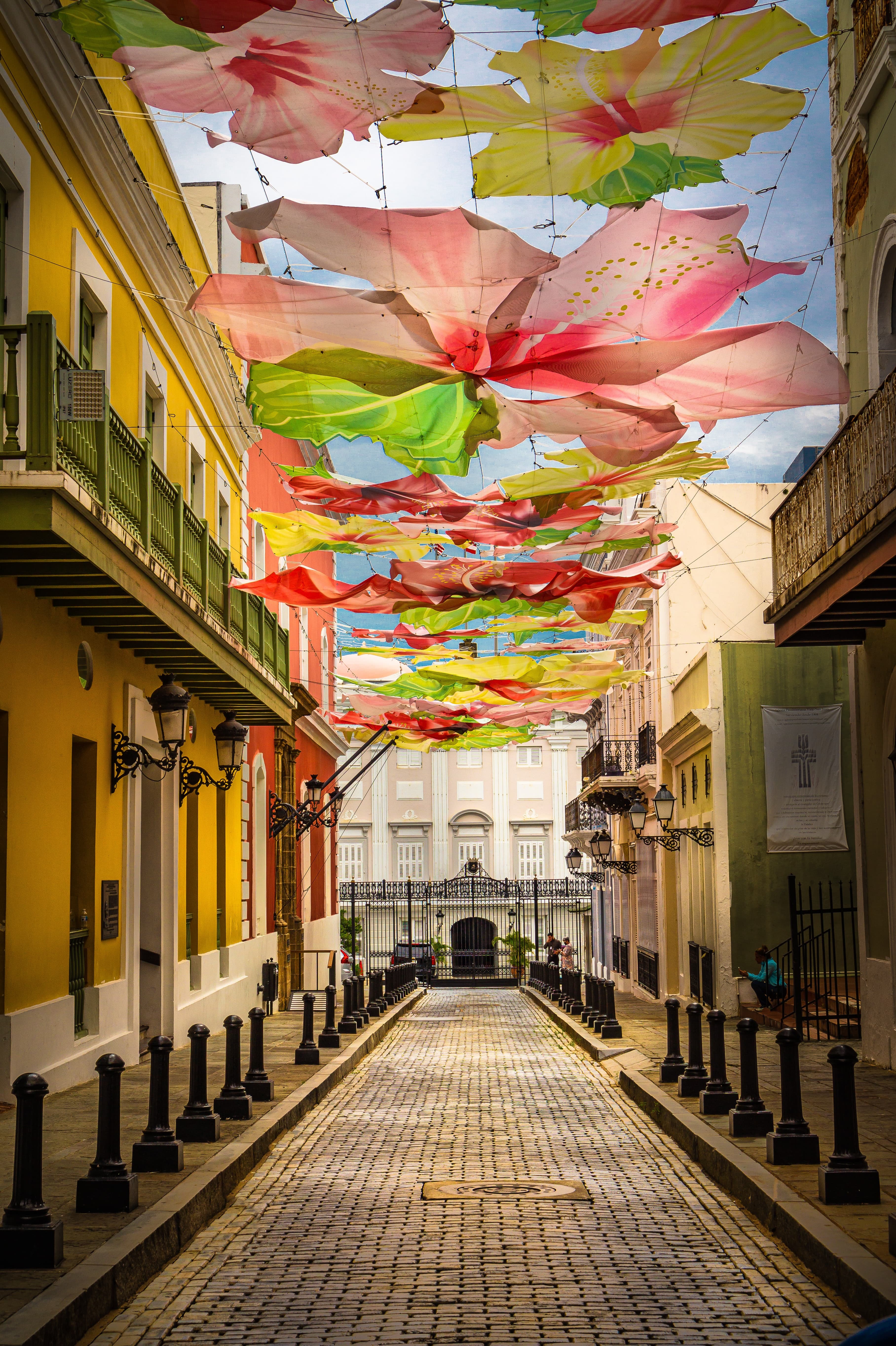 Street with colorful umbrellas hanging overhead during daytime