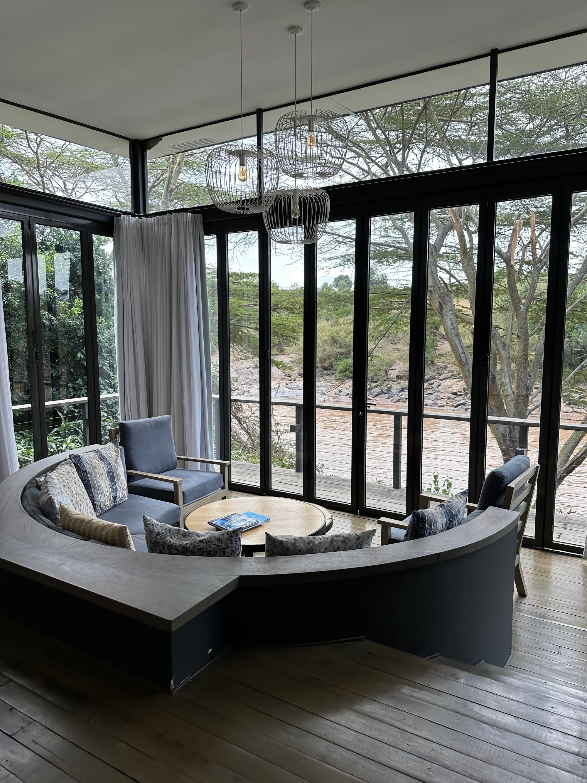 a circular couch in a fancy hotel room with floor-to-ceiling windows