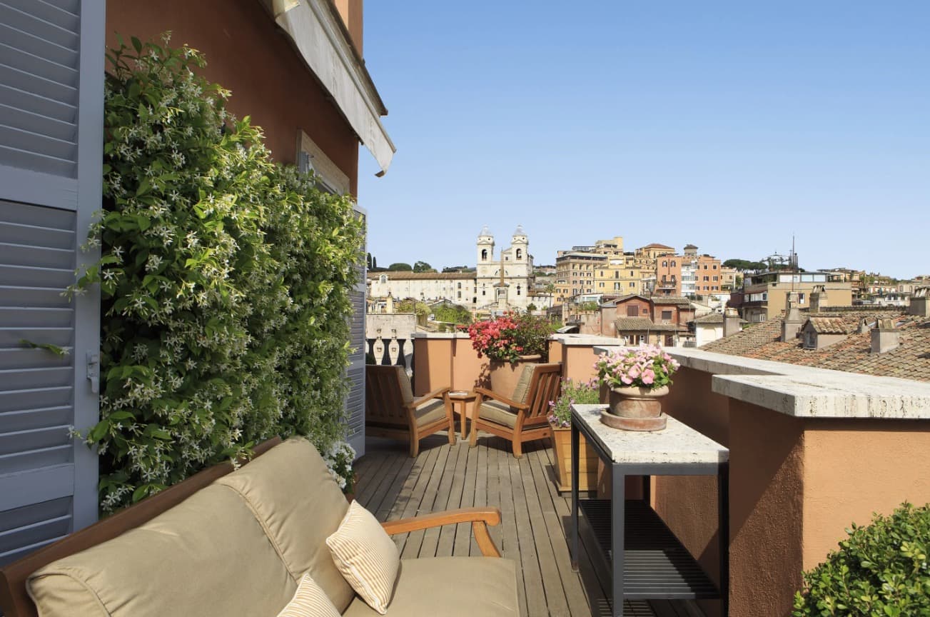 outdoor terrace overlooking rome with seating and flowers