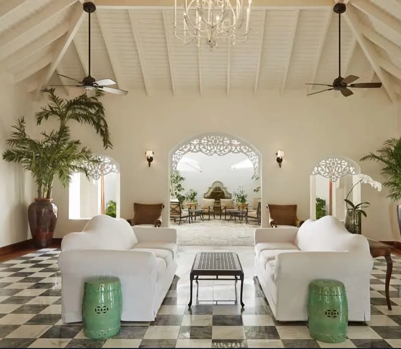 white painted room with tall ceiling and facing white couches and checkerboard floor