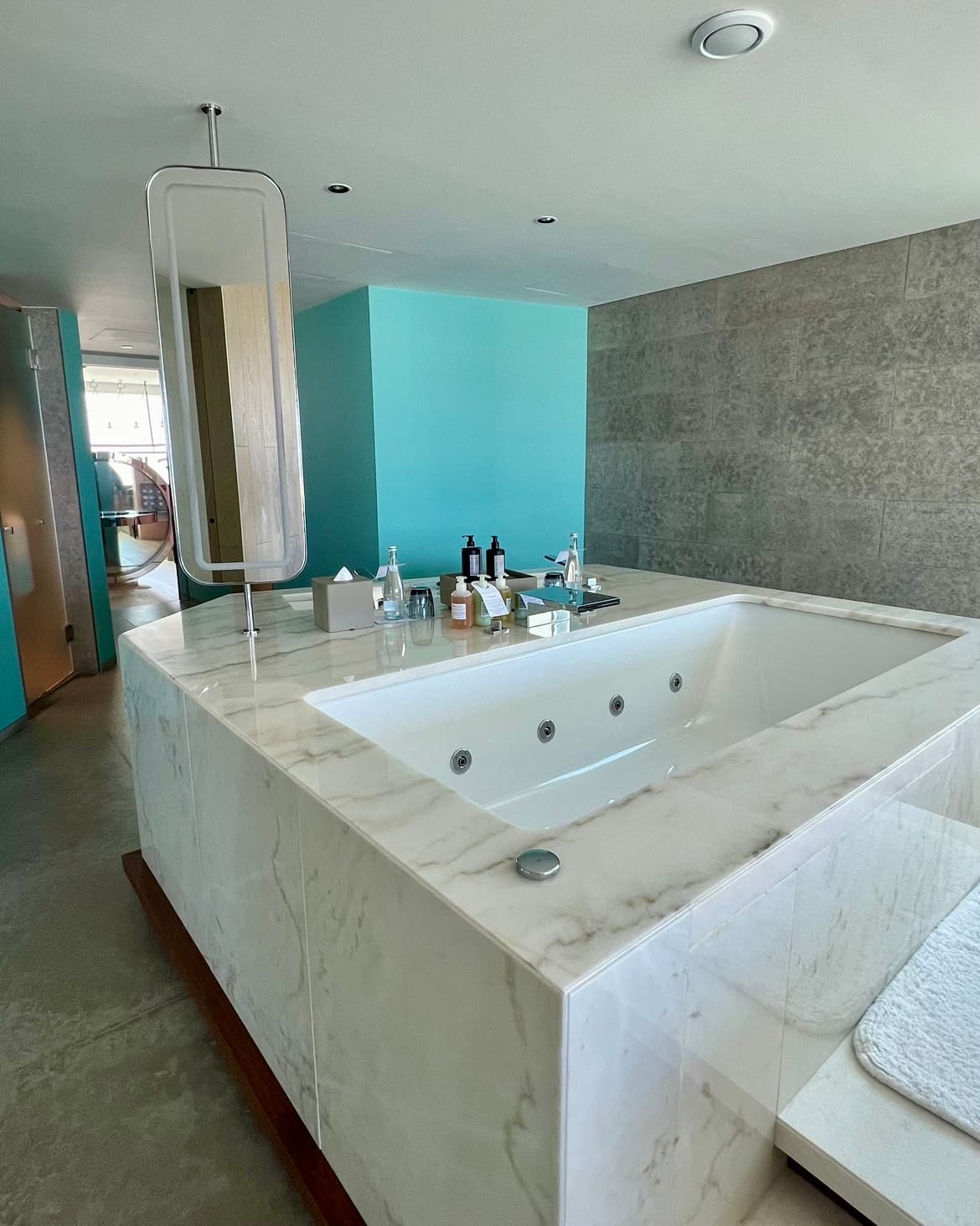 A bathroom with a large marble tub in the center