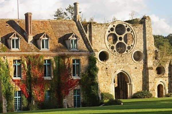 a stone manor façade covered in ivy
