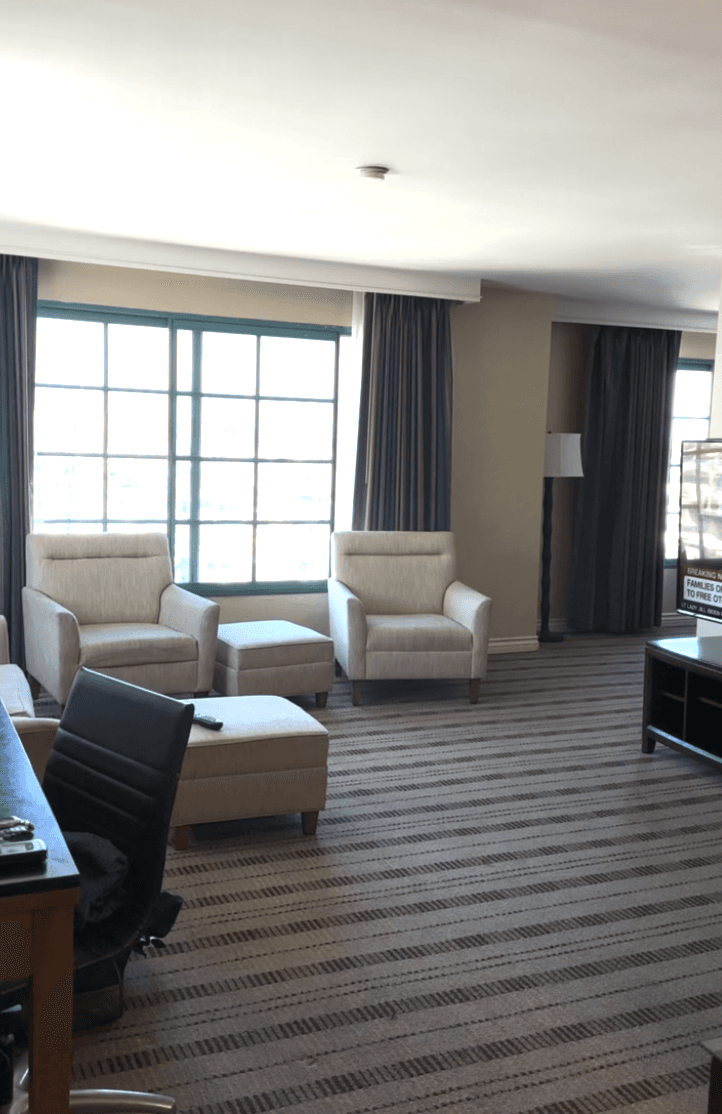 A set of white chairs in the middle of a hotel suite