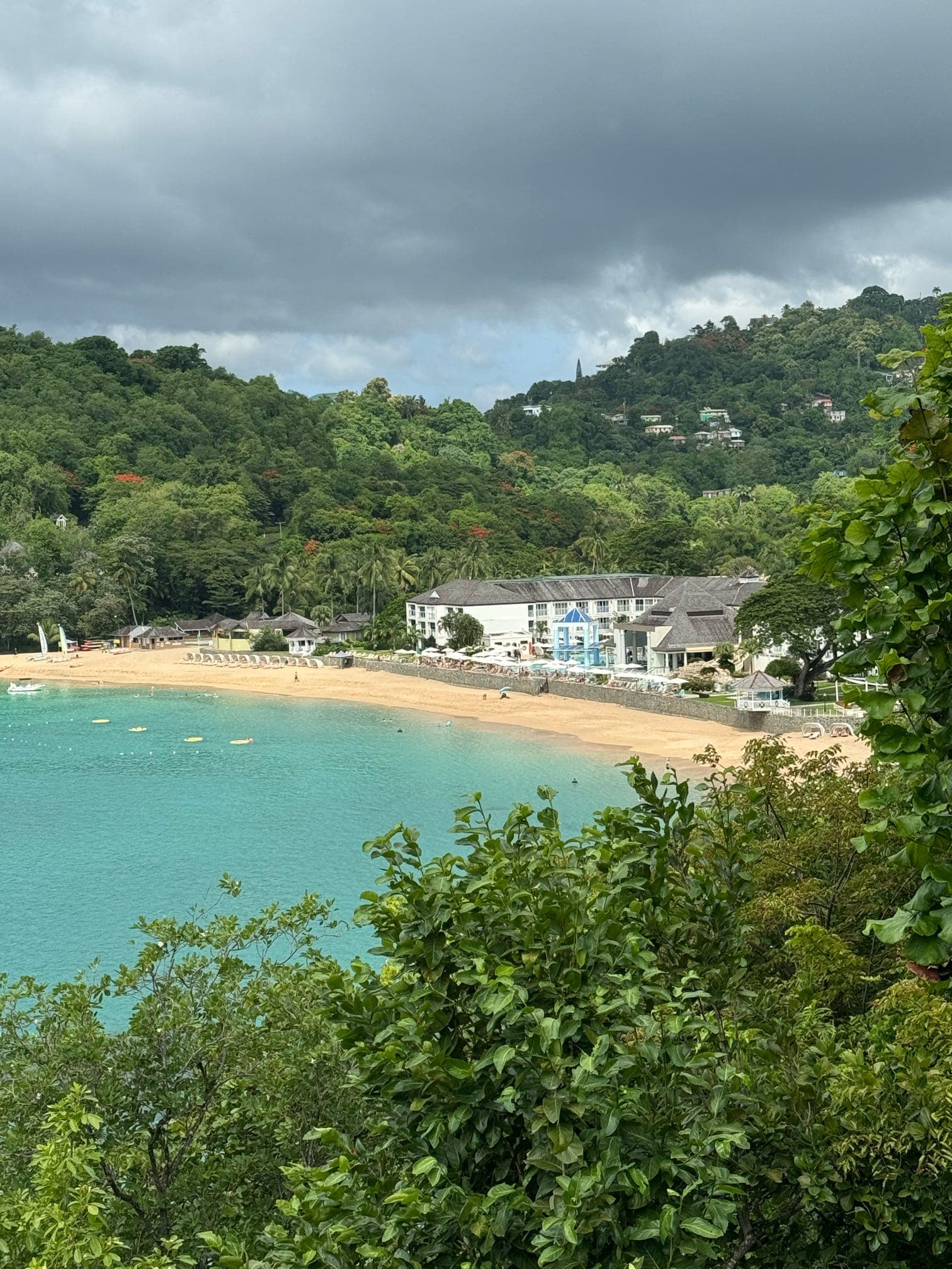 A beach area surrounded by mountains and lush greenery