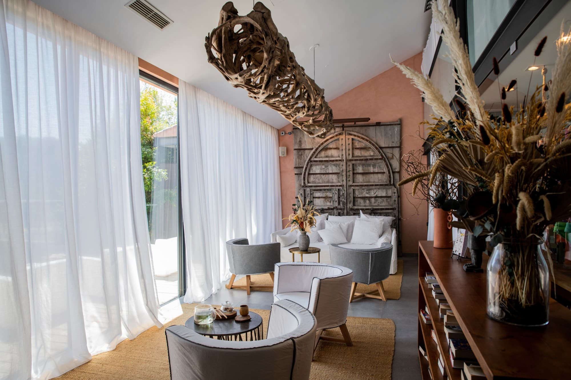 a serene waiting area with white plush chairs and a wooden light fixture hanging from the ceiling