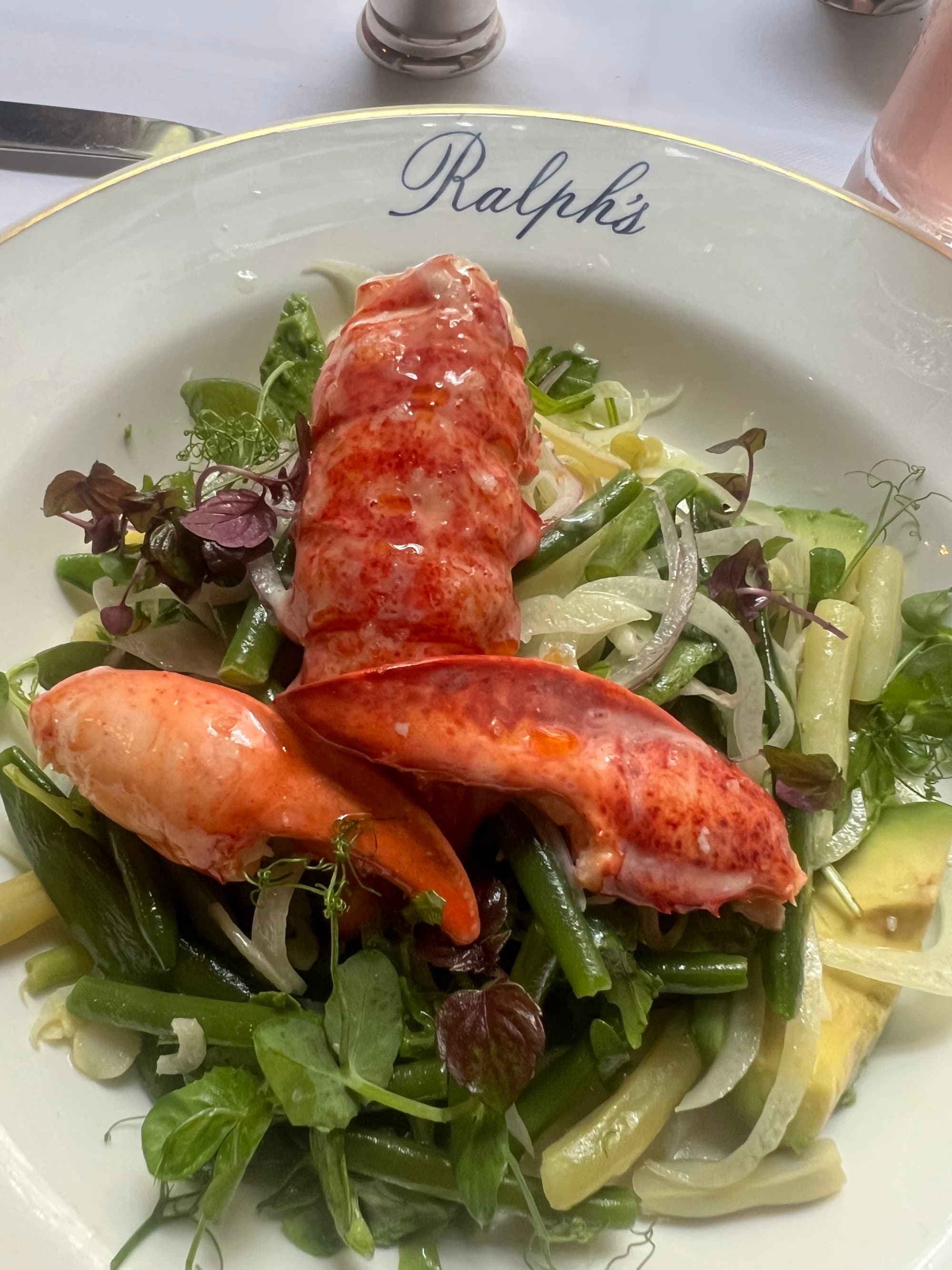 A salad on a plate with the word "Ralph's" printed on it