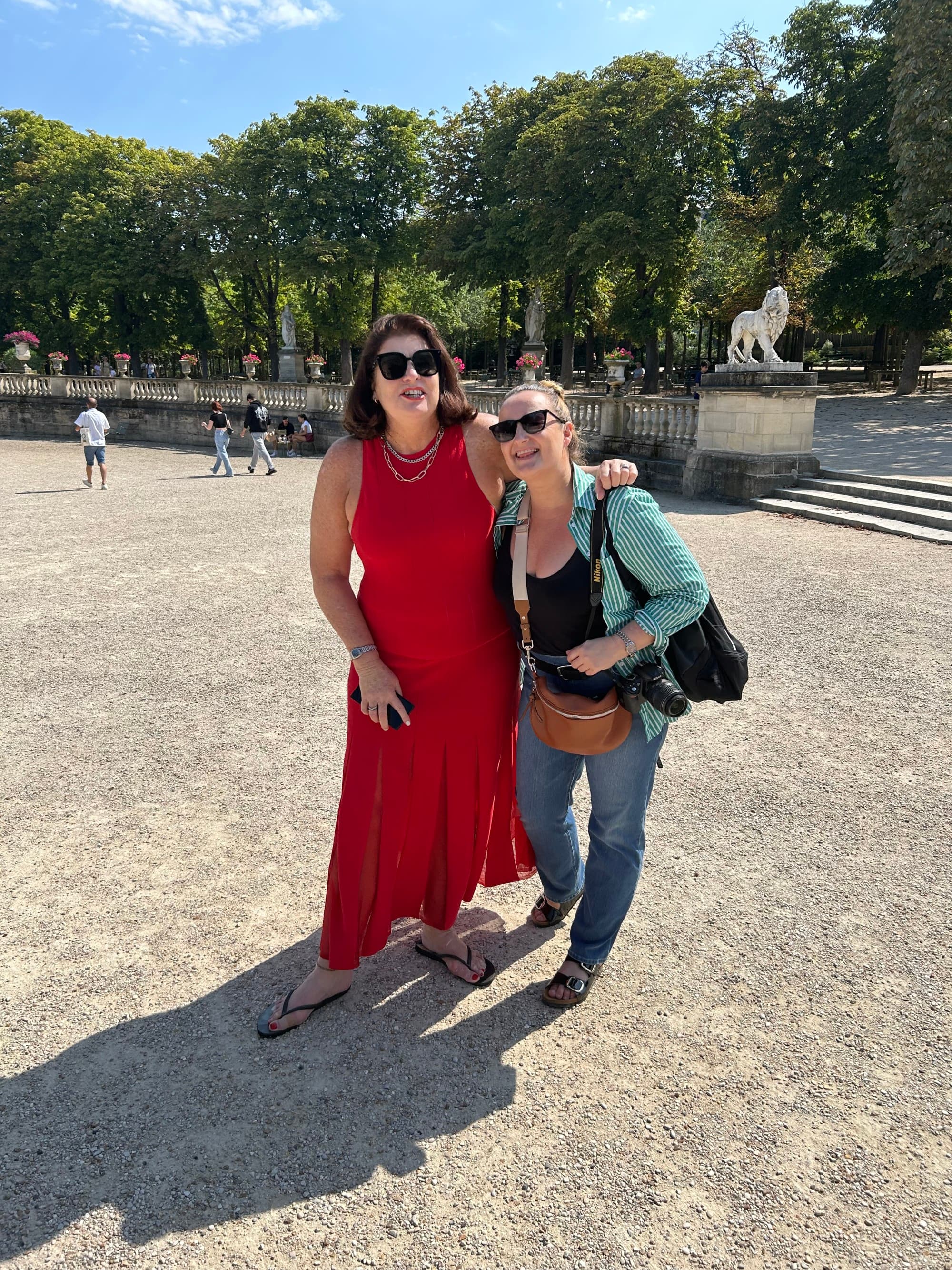 Two women standing in an outside courtyard area posing for a photograph together
