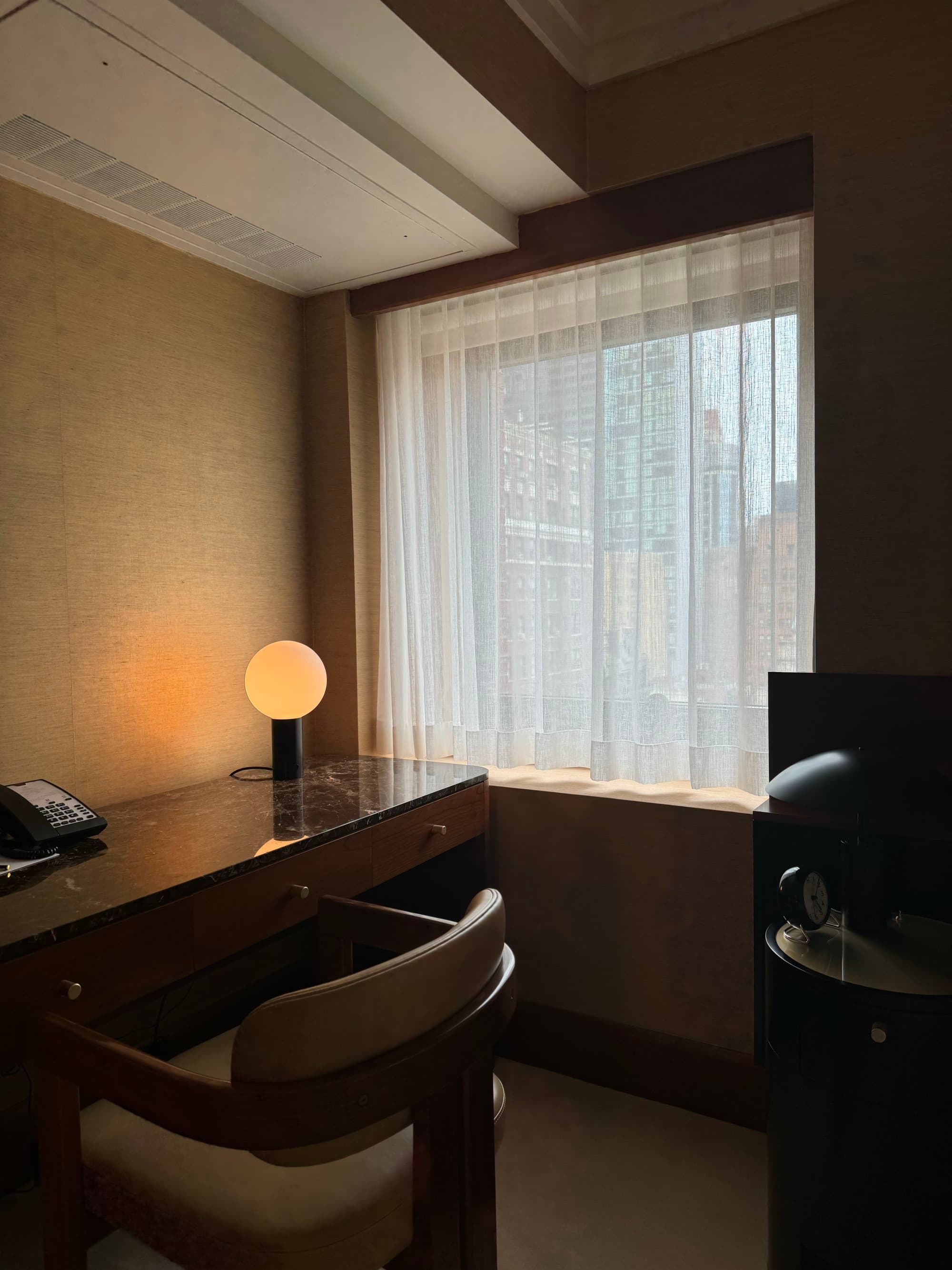 Sitting area with a desk and table lamp in the hotel room.