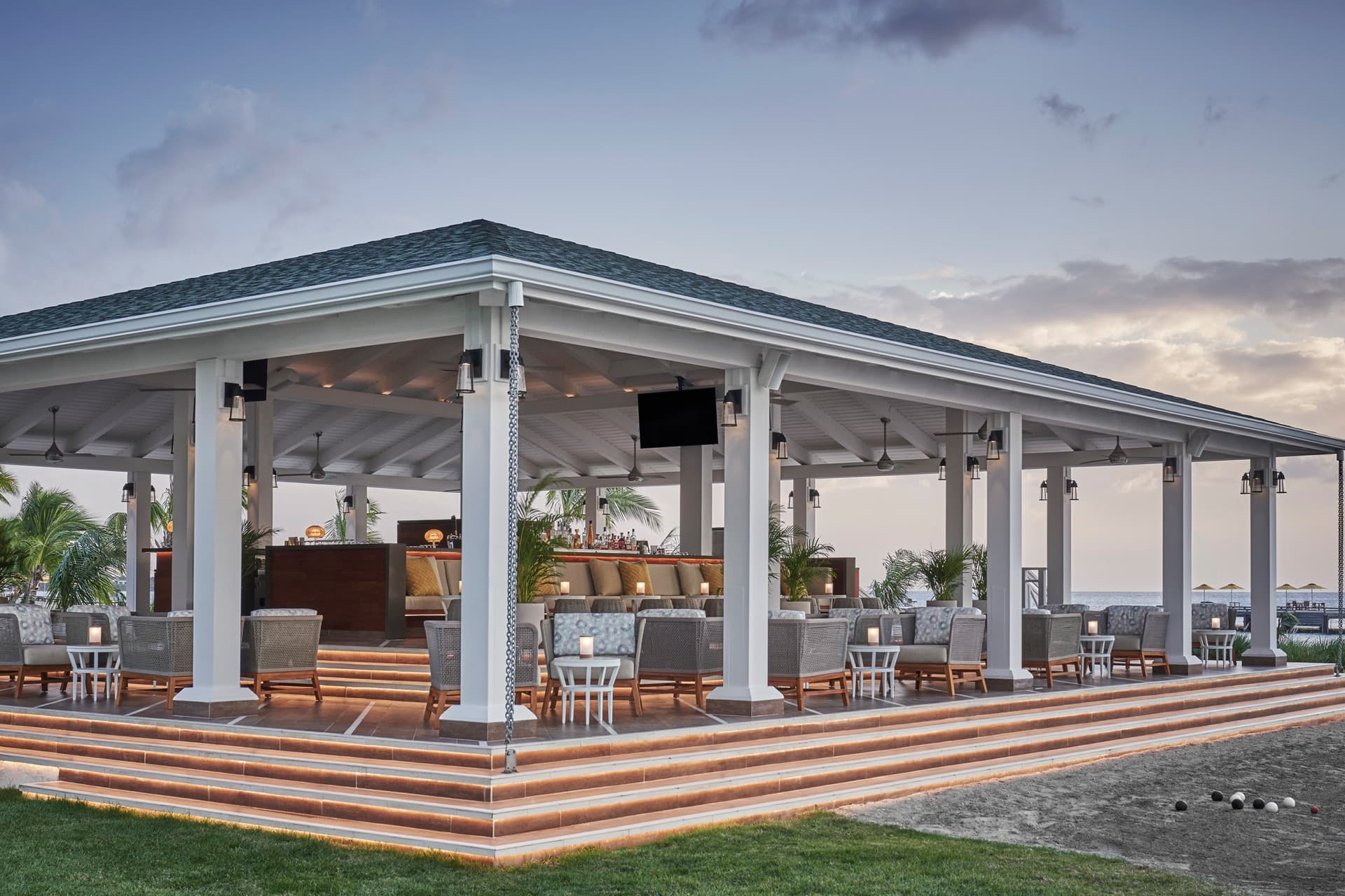 an outdoor covered dining area filled with elegant tables and chairs