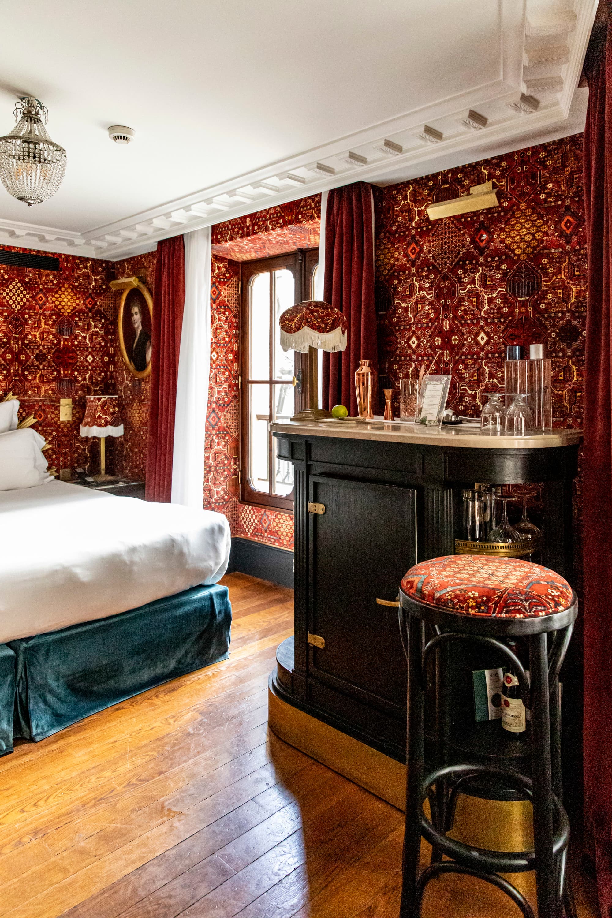 a luxe bedroom with vibrant red wallpaper and a private bar