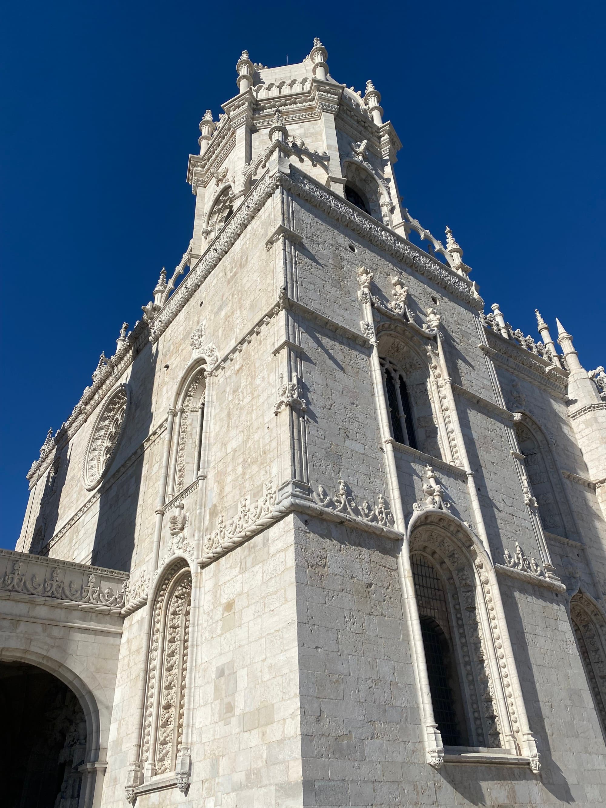 The view of a large, white monastery reaching toward the sky on a sunny day.