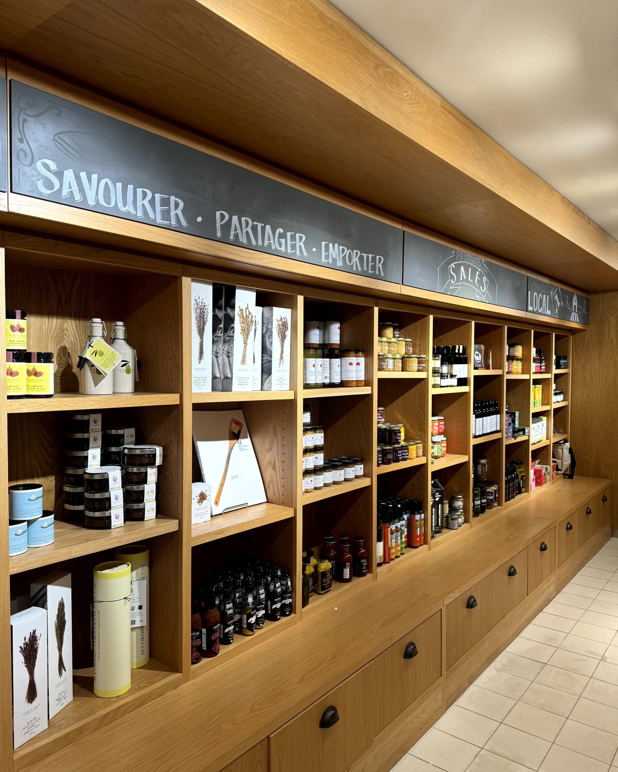 A view of wooden shelves filled with retail products for sale at Gastronomic Delights - Marche Artisans - Rondene Grinam