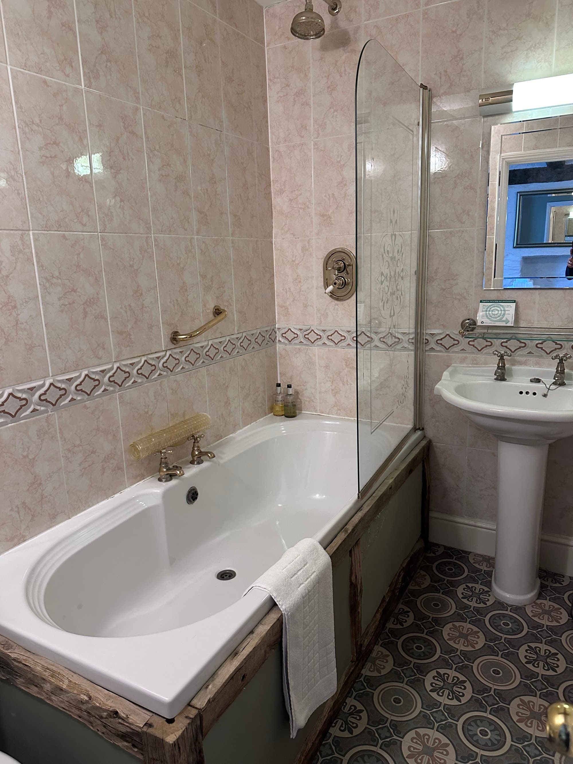 Bathroom with pink tile and a bathtub.