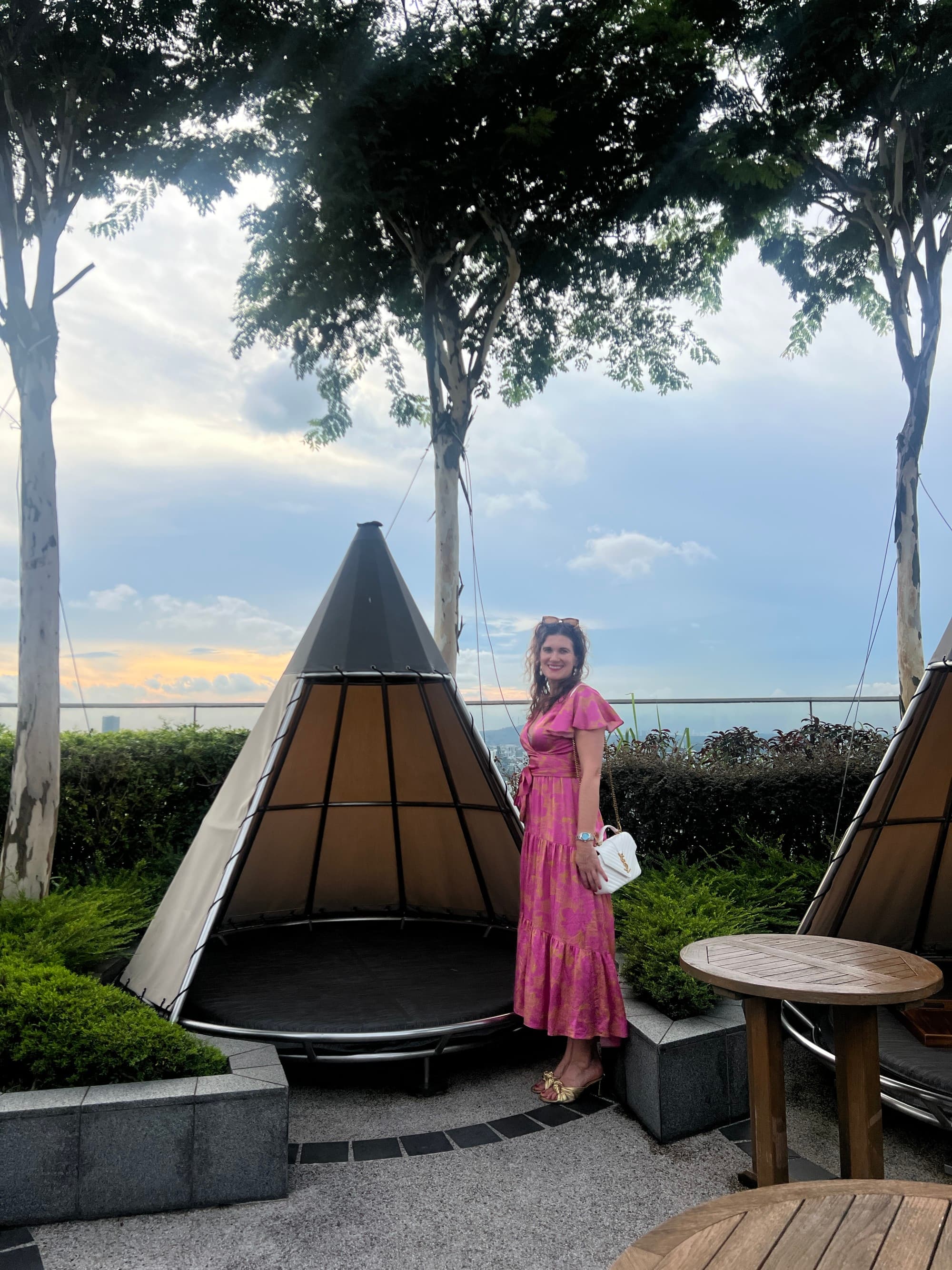Advisor in a pink dress standing next to a firepit.