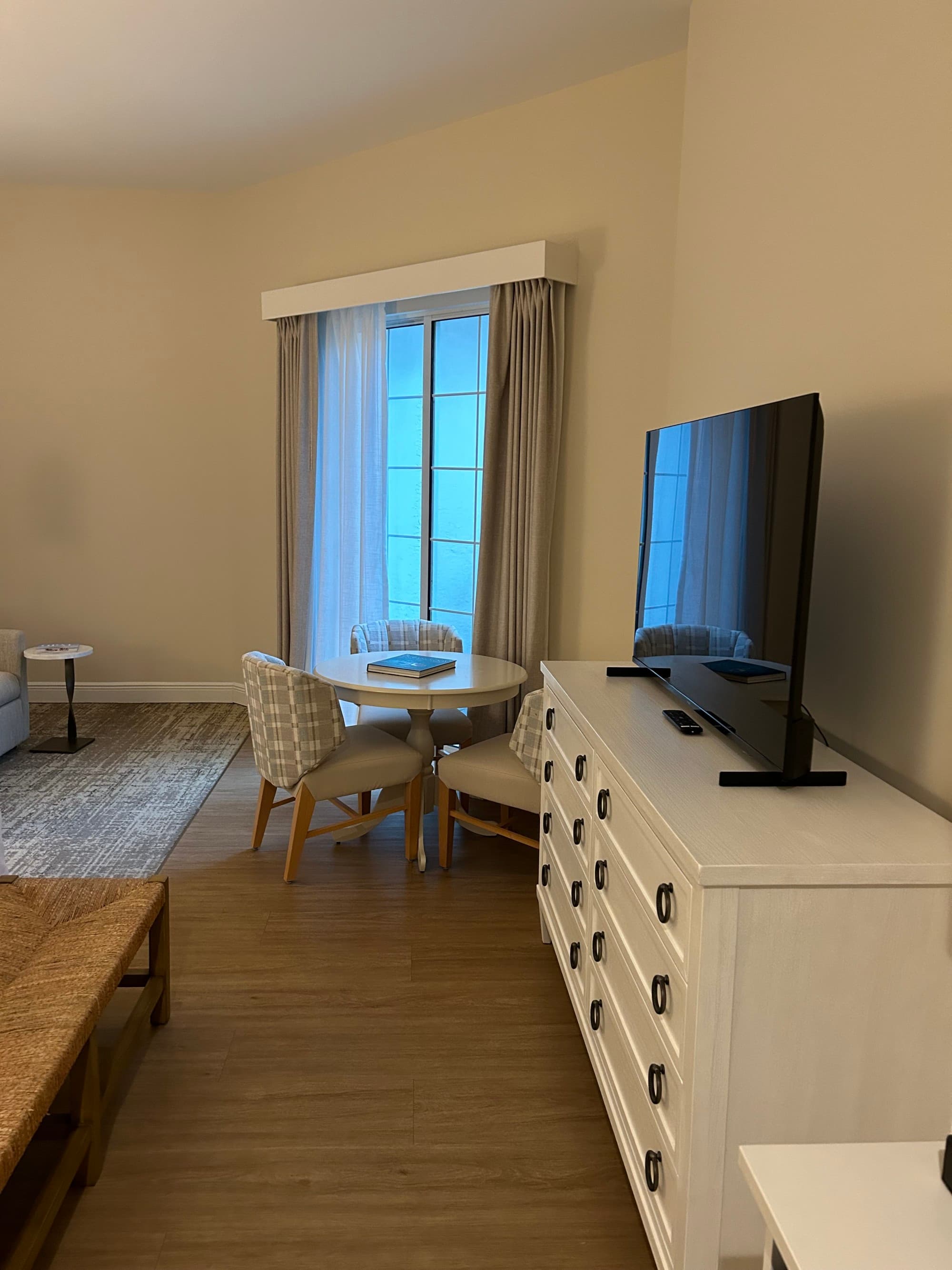 Guest room with a white credenza and flat-screen television.