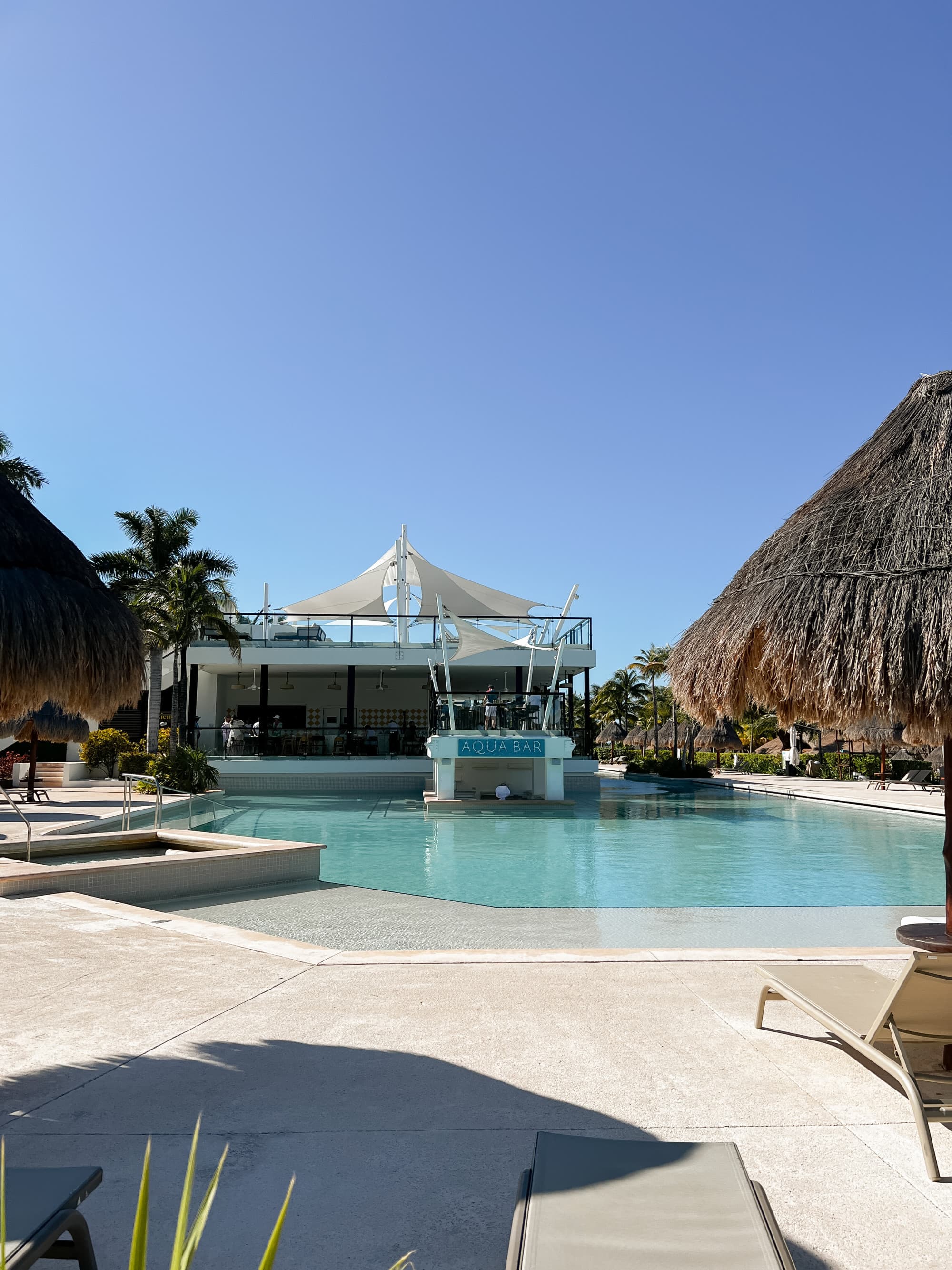 Blue pool with lounge chairs.