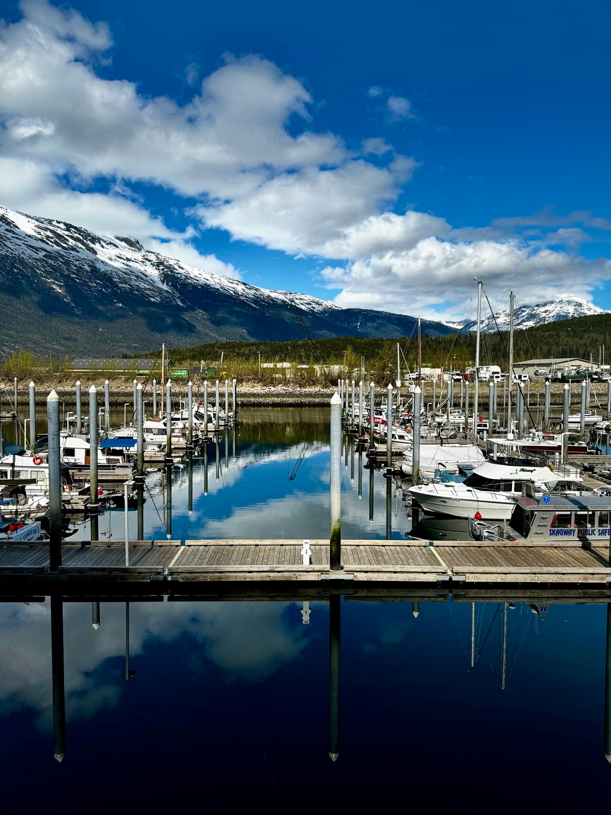 Harbor with sailboats and mountains in the background.