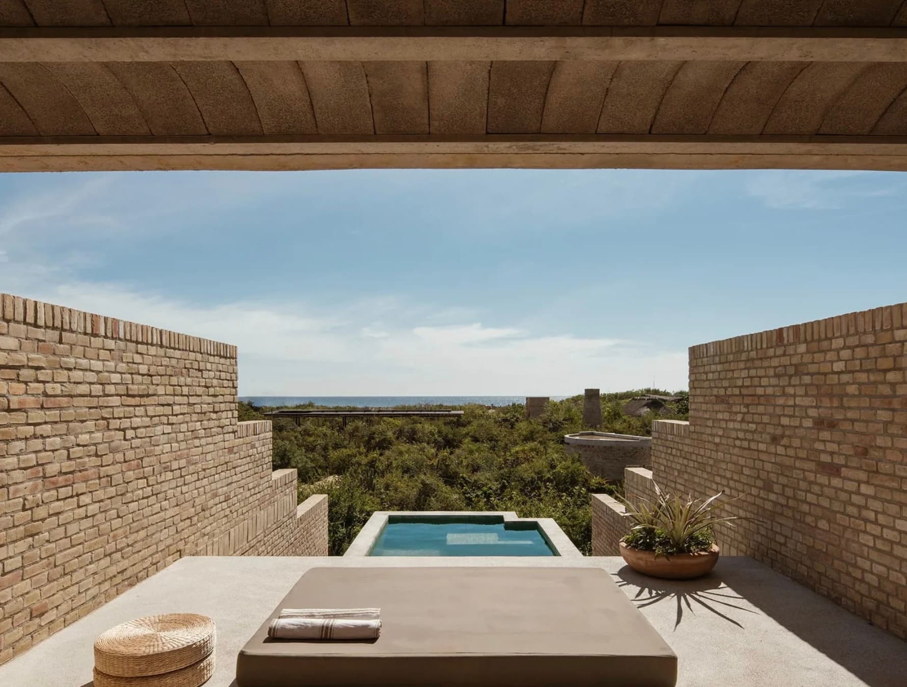 view looking toward the sea with a plunge pool and jungle beyond