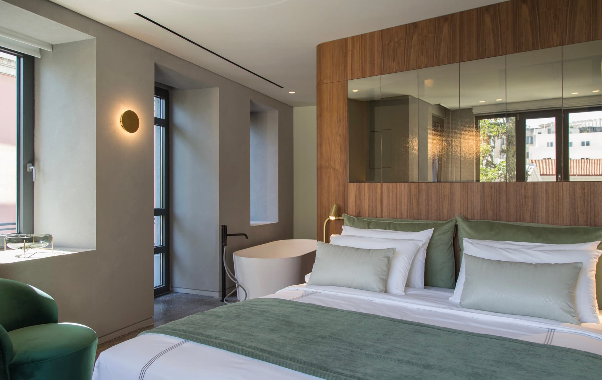 bedroom with a green blanket and a white soaking tub