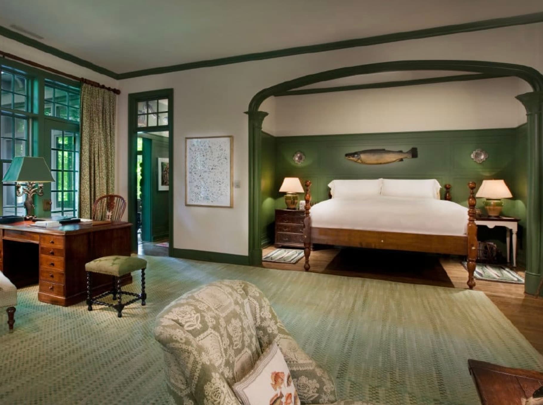 green and white room with bed and fish art