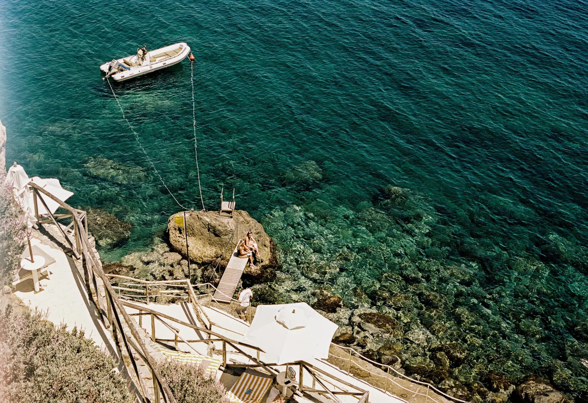 aerial view of people sitting on a wooden ocean pier