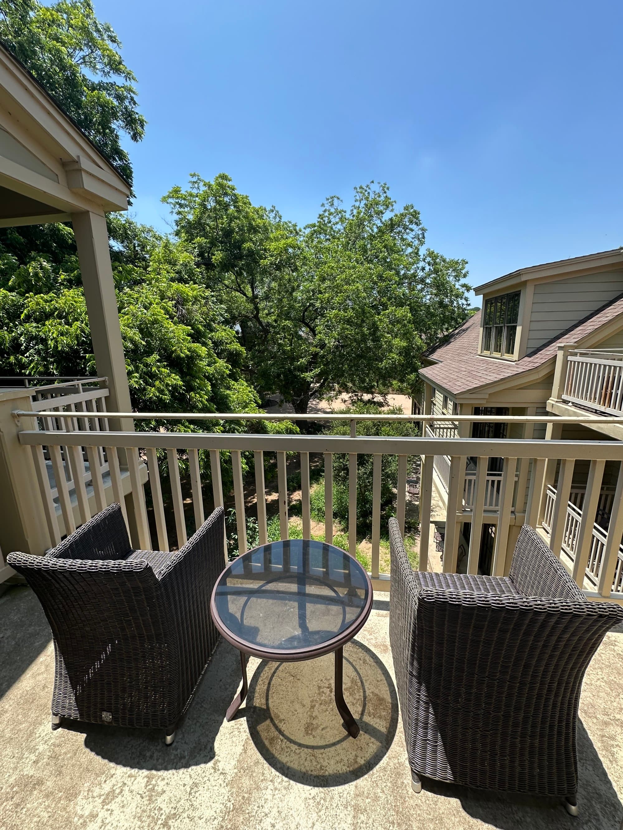 A balcony with two chairs and a round table