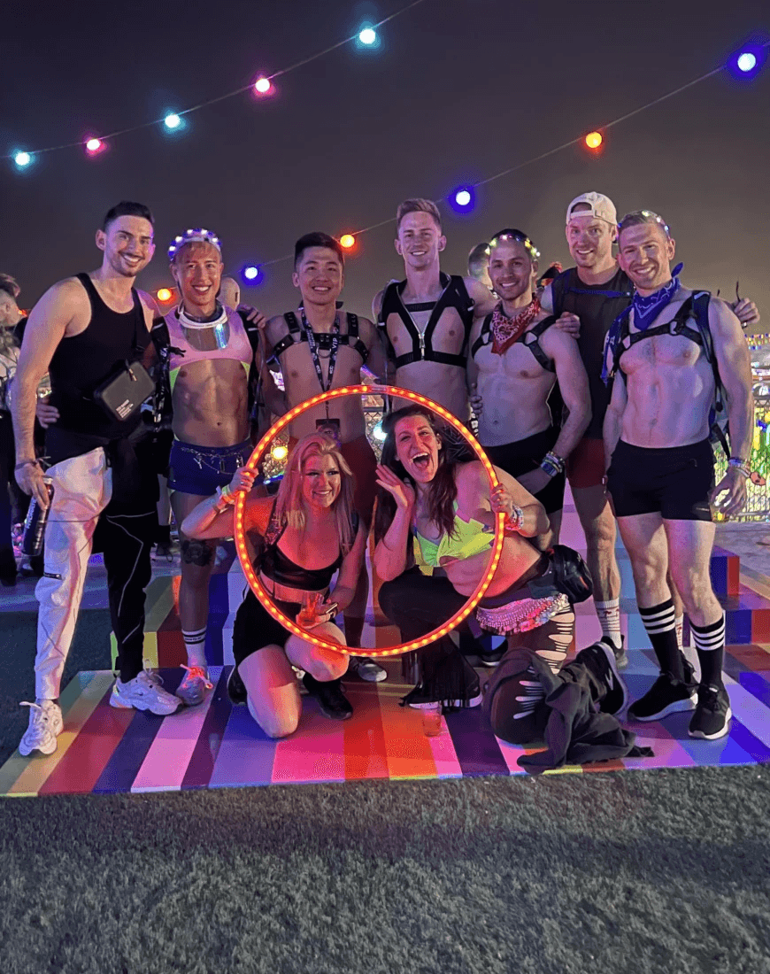 A group of people posing at a concert in Las Vegas with neon lighting
