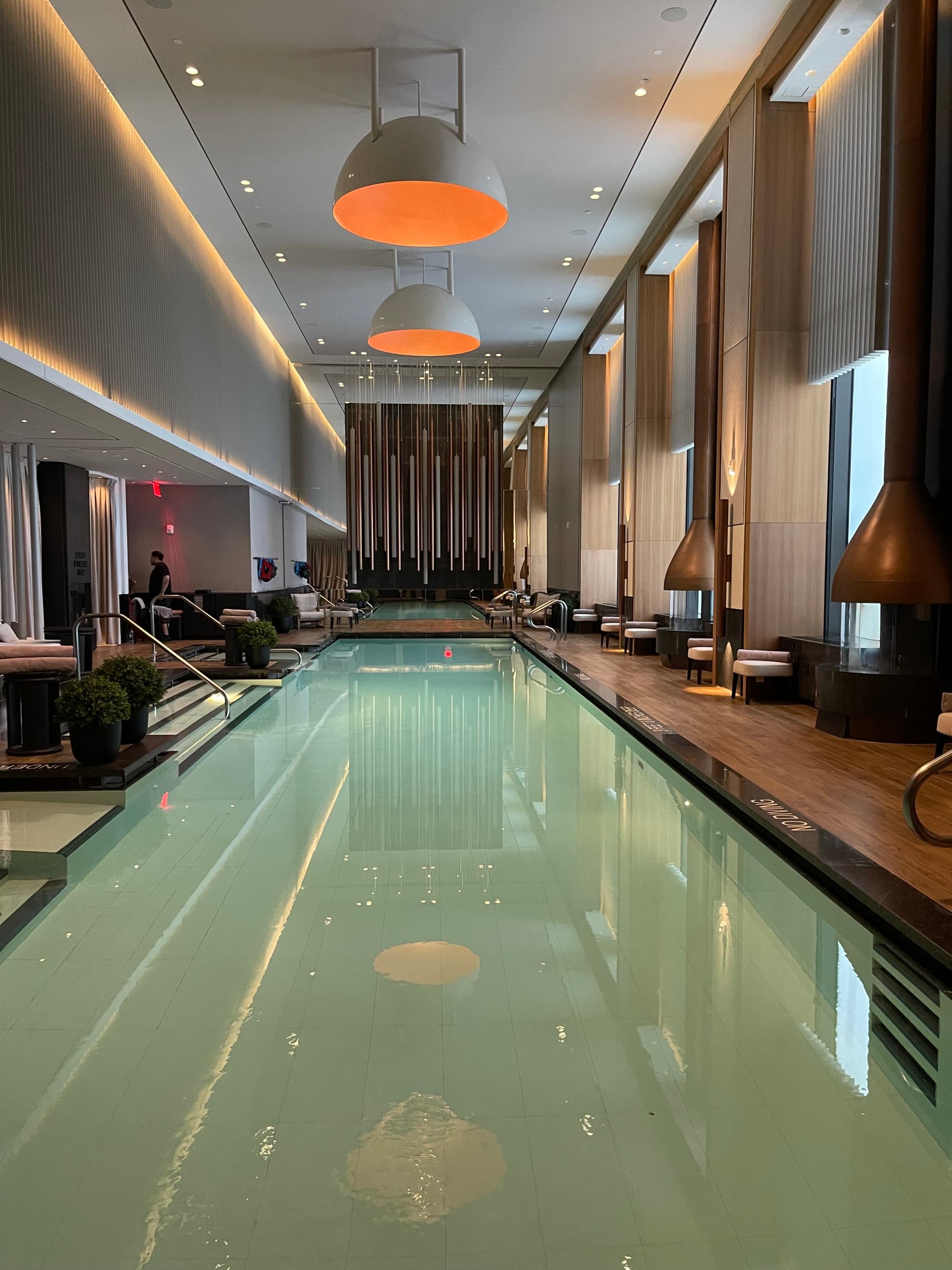 The rectangular, indoor pool, lined with cushioned seats and hanging, life-size wind chimes.