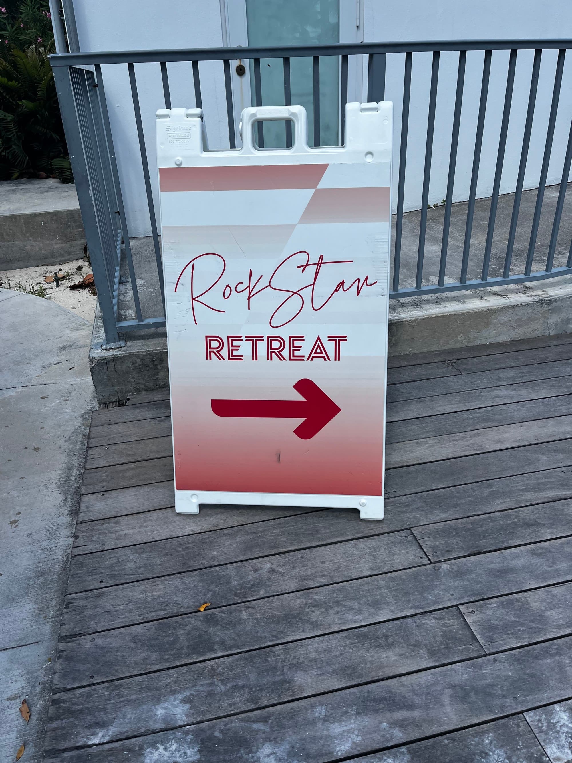 A sign on a wooden deck reading "Rock Star Retreat" with an arrow pointing to the right