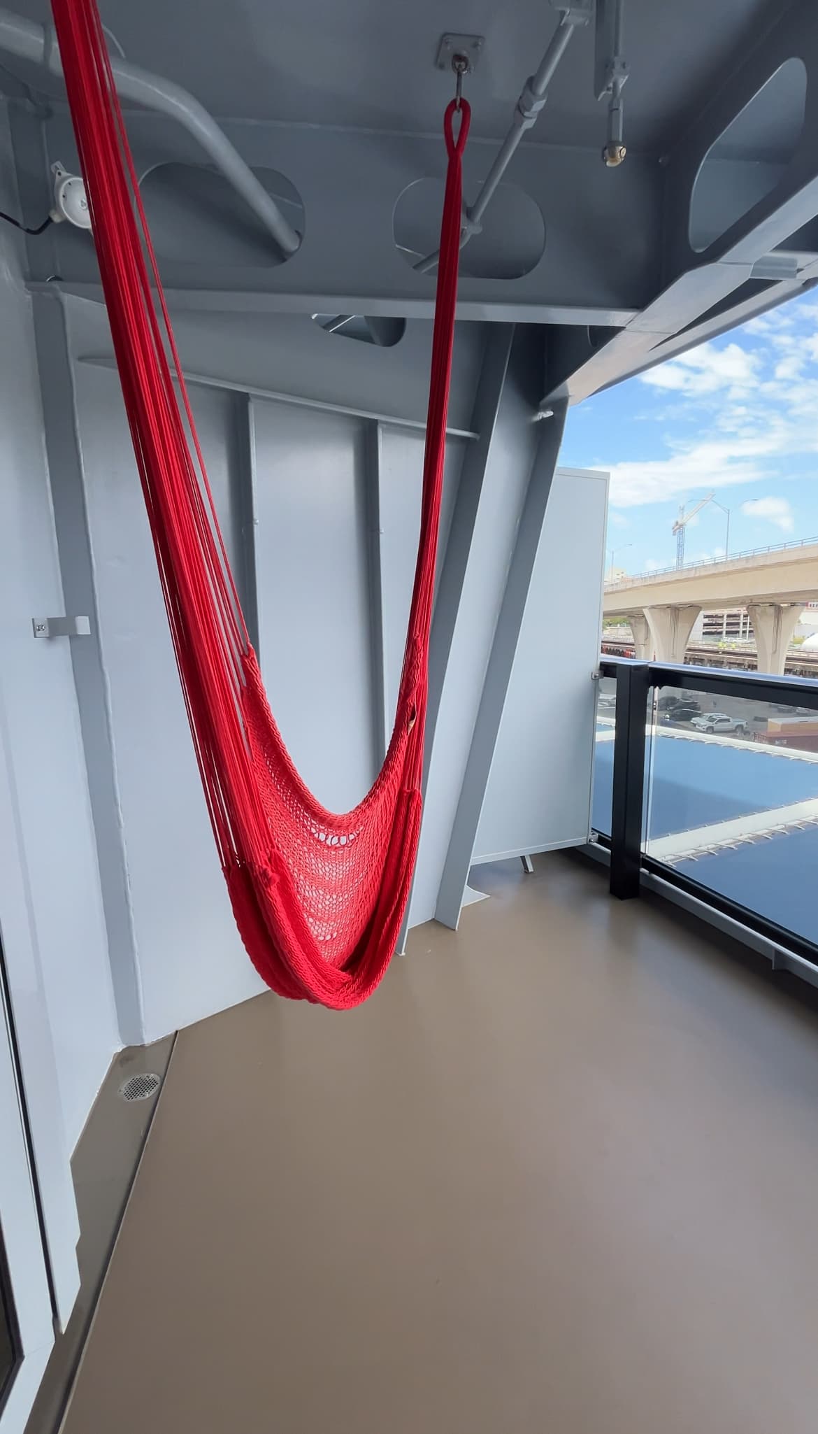 A red hammock hanging in a cruise ship balcony